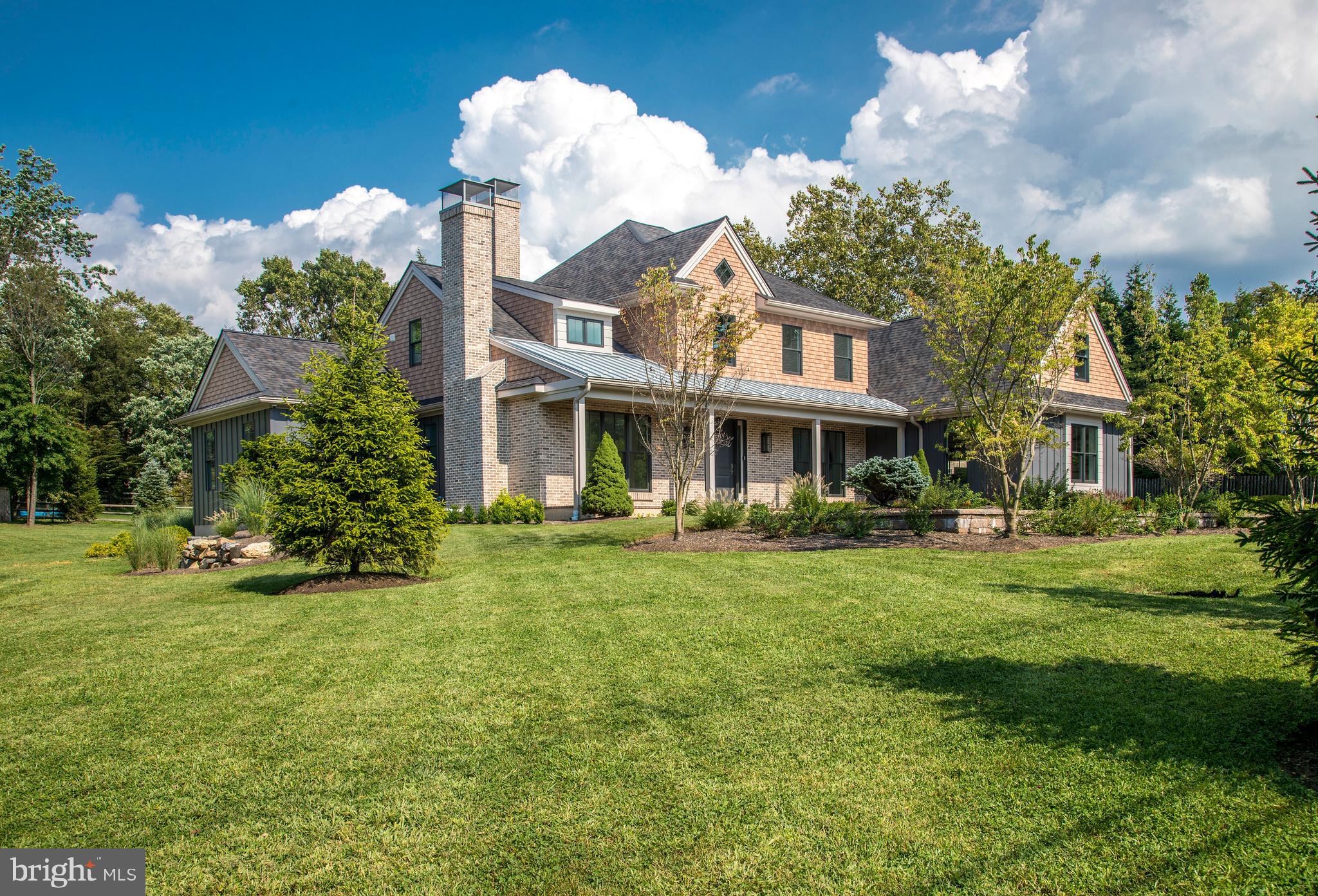 Main Line meets Modern: Pennswood, NBC Group's latest offering, brings a refreshing cosmopolitan flair to the classic Mainline historic landscape. This approximately 4800 sq. ft. new construction Wayne home boasts exceptional detail in form and function. Host your largest cocktail parties in this spacious show-stopper of a kitchen with its open concept design. Mingle and enjoy sights of your morning room, or family room with its highly desirable linear fireplace on a brick feature wall. Or spill out to your adjoining oversized veranda, with surprising comforts, to toast good friendships. A complete tour of the first floor would also consist of your entrance foyer, galley, and spacious dining room with butler pantry, study, 2 powder rooms and a mudroom. Retire to your First floor Master suite with a luxurious bathroom and walk in closets. Upstairs features your second master en-suite, 2 additional bedrooms and the second full bath on this floor. Additionally, your main laundry/craft room and adjoining storage room completes this level. The now finished walkout lower level offers a large rec room, gym, screen prepped for either golf simulator or movies, wine cellar, possible 5th bedroom and a full finished bathroom . During the day, enjoy your property's new custom landscape with mature trees and welcoming hardscape before popping into town. Wayne town is moments away, and Downtown just 25 minutes by car. NBC Group AND YOU! - "addressing excellence" on the Main Line.