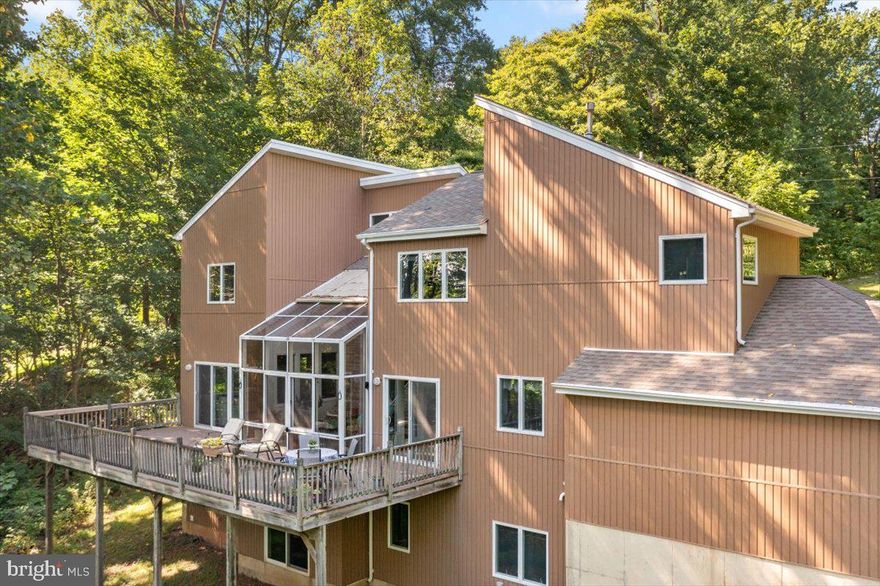 Your Mountain Sanctuary Awaits... Like a rare gem nestled in the perfect setting, this home on Solebury Mountain Road is ready for you to discover. This contemporary retreat radiates creativity and charm and offers the stunning seasonal views that Bucks County is famous for. This unique home in its unique setting may be the mountaintop retreat you’ve dreamt of.  A hidden treasure , tucked away on one of the most scenic  roads in Bucks County, located just minutes from the vibrant river towns of New Hope and Lambertville and from the popular County Seat of Doylestown... you will also find big-city accessibility. Just 90 minutes from Manhattan and an hour from Philadelphia,  this location provides the perfect balance of tranquil  country living along with convenient access to two of the largest metropolitan areas on the East Coast. Whether you're in search of a peaceful retreat or a gateway to world-class cultural, dining, and entertainment options, this is an ideal spot to call home.
You'll approach the property on the wonderful winding road atop  Solebury Mountain's and come to the serene cul-de-sac location of number 40. You're sure to be struck by the peaceful stunning landscape and peaceful ambiance of the home's setting amidst trees. The views are spectacular from each window.
When you enter the home, you'll be greeted by an impressive stone wall in the foyer which sets the stage for the continued architectural marvels inside. A spacious living room, where high ceilings and a grand stone wood-burning fireplace create a welcoming focal point and there is abundant natural light that pours in through numerous windows. Like every home, its kitchen is its heart and this one is expansive and features crisp white cabinetry and ample counter space. Adjacent to the kitchen is a charming breakfast area, perfect for casual meals, while there is also a  formal dining room,  providing a splendid setting for gatherings and celebrations. 
Perhaps the most distinguishing highlight of the home is the central solarium.  Unique in concept, it offers an enchanting view of the ever-changing landscape throughout the year. The home's orientation was carefully chosen to maximize energy efficiency. The strategically positioned passive solar solarium faces south in order to capture winter heat... it's the perfect spot in the home to enjoy the vibrant growth of spring, the lush greenery of summer, the fiery autumn foliage, and the peaceful snow-covered landscape in winter. The solarium not only offers stunning views but also contributes to the home's energy efficiency.
Upstairs you'll find four generously sized bedrooms and two full bathrooms. The ample-sized primary bedroom features an en-suite bathroom and a custom-designed closet with ample storage and shelving.
The lower level offers versatile space with various rooms that could serve in any number of functions... a gym, additional living areas or guest quarters. There is a room on the lower level that could be an extra bedroom, as there is a full bathroom, adding to the many conveniences and functionalities of the home.
In the rear of the home is a  massive deck, perfect for grilling and outdoor entertaining... and, of course, the wonderful  tree-surrounded view. Yes, this unique and captivating home on Solebury Mountain Road is a rare find, offering a blend of contemporary design, natural beauty, and year-round serenity. Don't miss the chance to make this exceptional property your own. Schedule a viewing today and experience the magic for yourself.