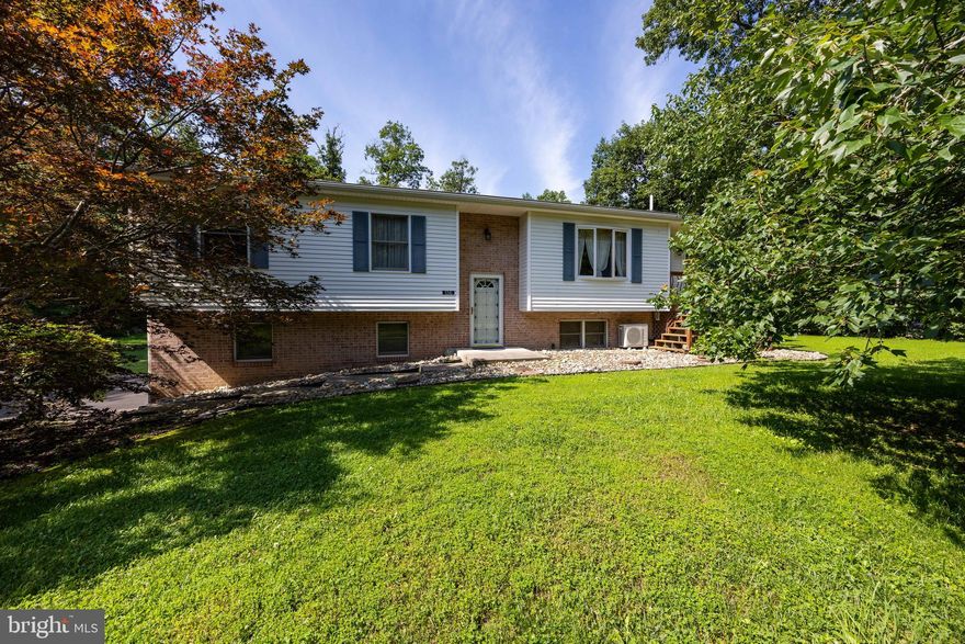 This home is a true hidden gem! Nestled on nearly an acre in a peaceful country setting, 136 Tupelo Drive offers comfort, charm, and convenience. With 3 bedrooms, 2 baths, and over 2,000 square feet of well-maintained space, it’s move-in ready and perfect for everyday living and entertaining. You’ll love the open main level with its bright living area and thoughtfully designed kitchen—featuring Silastone counters, a breakfast bar, and smart storage. Just off the main living space, the sunroom is a standout feature—flooded with natural light and offering a tranquil spot to enjoy your morning coffee, unwind with a book, or take in views of the lush, tree-lined yard.

Downstairs, the large rec room invites you to relax, work, or play, with a separate laundry room and extra storage to keep things organized. The two-car garage is full of thoughtful touches like built-in shelving, a garage vacuum, and remote openers. Surrounded by mature trees, a vibrant lawn, and beautifully landscaped gardens that bloom year-round, this home offers the perfect blend of privacy and beauty. Located in the desirable Hedgesville school district and just minutes from Route 9—don’t miss your chance to make this special property yours. Schedule your tour today!