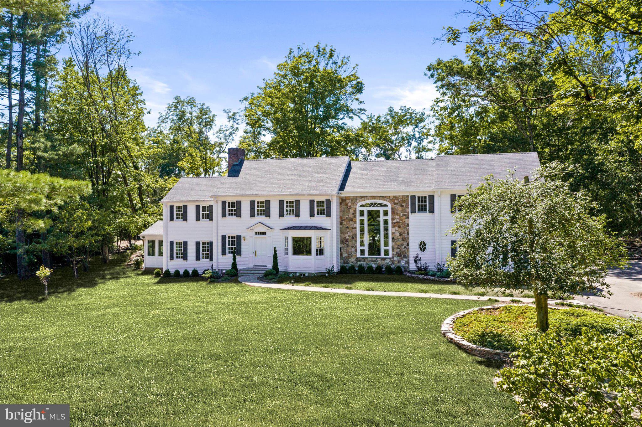 Boldly expanded, renovated and reimagined in 2022 by an award-winning builder, 94 Fairway Drive presents stunning contemporary features, merged artfully with the original neo-colonial signature of architect Rolf Bauhan. 5300 sq ft of beautiful living space. 1000 sq ft finished walk out basement with full bath. 600 sq ft unfinished basement. Over half of the living space is new construction. The redesign includes a modern open floor plan, luxury appointments, bespoke finishes, and all-new household systems including a whole house generator. The house is all about light. A two-story atrium window with an 18’ stone feature wall welcomes morning sunlight through a dramatic floating staircase with cherry treads, glass railings, and a glass balcony. Large picture windows on two levels frame magical sunsets over two newly constructed bluestone, soapstone, fieldstone and brick patios complete with fire pit. A spacious living room with a paneled wall and marble fireplace is flanked by a cheerful sunroom/office space with wraparound glass, and a separate study/library with a gas fireplace and built-ins. Open floor plan kitchen, dining, and family rooms share a beverage center with wine cooler. When privacy is desired, French pocket doors divide the open space into separate rooms. The expansive kitchen/breakfast room features custom cabinetry, a cherry island topped with figured marble, and all-new Sub-Zero and Wolf appliances. The primary bedroom suite is a haven of opulence with 10’ ceilings & skylights, two walk-in closets, a private balcony overlooking the patios, and a spacious bathroom with radiant heat and glass double barn doors into a wet room with tub and two showers. Two more luxury suites occupy either end of the 2nd level. A hall bath serves two central bedrooms, one with a whimsical Romeo & Juliet French leaded glass casement overlooking the two-story atrium. The finished walkout basement adds an additional 1000 square feet of living space, including a media room or gym with 10’ ceiling, a game room with full bath, and a wine/beverage center. An additional 600’ of unfinished basement contains a second laundry room and storage space. The property is freshly landscaped and hardscaped ... flat two-acre lot in Princeton’s upscale Brookstone enclave. Schedule a private showing and see why this architecturally intriguing home surpasses other high-end offerings in Princeton. 2 car garage side entry. 5 plus parking spaces. Both beautiful home and flat property ... available immediately. Important for new owner is the Whole House Generator included. Virtual tour available. Photographs available. Floor plans available. Disclosure available. Please visit all. ***Front facing East. ***Rear facing West.