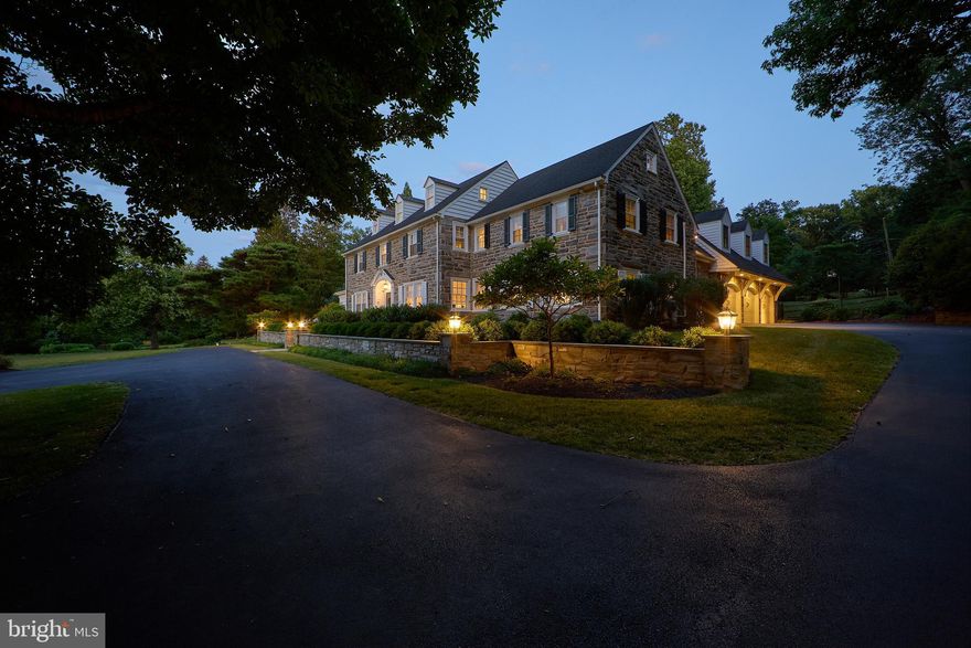 From the moment you approach this stunning stone house, the meticulous attention to detail is unmistakable. Its stately elegance, craftsmanship, and timeless design reflect a bygone era when exceptional homes were crafted with care and precision. This quintessential Main Line residence showcases pure sophistication, starting with its impressive stone exterior, which evokes a sense of awe. The newly added stone retaining wall, manicured landscaping, lush lawn, and parking court only enhance its grandeur.

Step through the striking Federal-style front door with leaded sidelights, and you're greeted by a front-to-back foyer featuring a gracefully turned staircase. The foyer is flanked by both the formal living and dining rooms. The expansive, light-filled living room boasts large windows with picturesque views of the backyard and pool. At its heart, a wood-burning stone fireplace with a detailed mantle adds warmth, surrounded by built-in display cabinetry and French doors on either side. These doors lead to a cozy den or office, complete with built-in bookshelves, perfect for quiet moments or focused work.

On the opposite side of the foyer, the formal dining room continues the home's tradition of fine craftsmanship, with classic millwork and deep windowsills. Beyond the dining room, you'll find another timeless feature—the butler’s pantry/bar area—leading to the large eat-in kitchen. This space, undoubtedly the heart of the home, is ideal for both daily meals and entertaining guests. The main floor also includes a beautifully designed laundry room with custom cabinetry, providing ample storage and access to the basement, outdoors, and a back staircase. Across the breezeway from the kitchen is a recently added oversized, three-car garage.

Upstairs, the center hall staircase leads to a spacious primary bedroom with an updated ensuite bath. Three additional generously sized bedrooms, all with hardwood floors, share a full bathroom and have easy access to the back staircase. A special bonus on this floor is the addition above the garage. This versatile space, with its private entrance, large closet, full bath, and built-in mini fridge, offers endless possibilities—it can serve as a second master suite, in-law or au pair suite, office, gym, or as a family room, as it is currently configured. The back staircase leads to the third floor, where you'll find an additional bedroom with a full bath, along with a storage area and walk-in cedar closet.

Beyond the home’s exquisite craftsmanship, the backyard is a true showstopper. Designed for relaxation and entertainment, the outdoor space features a stamped concrete patio with two tiers. The lower patio is perfect for dining, gathering, and cozying up by the gas fireplace on cool evenings. The stunning pool, with its serene waterfall and sun deck, provides a perfect spot for lounging or for little ones to splash around. For convenience, a full bathroom services the pool area. With mature landscaping, privacy fencing, and a peaceful atmosphere, this outdoor paradise is ideal for hosting gatherings or enjoying quiet evenings under the stars.

This exceptional property blends classic charm with modern amenities, offering a versatile and comfortable living experience. Located just a short drive from Downtown Wayne, the King of Prussia Town Center, KOP Mall, Valley Forge Park, and major thoroughfares, this home combines the best of Main Line living in an unbeatable location.