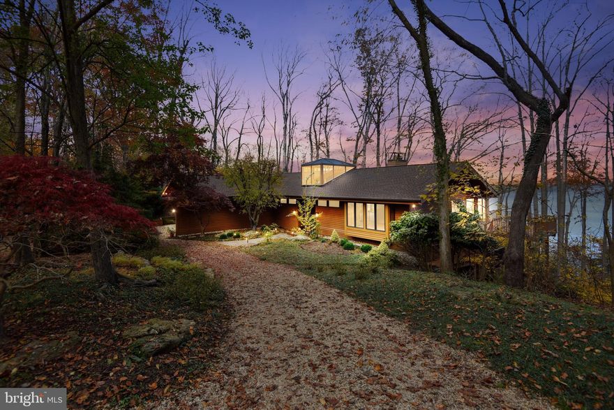 The community of Bayberry Hill is located on a stunningly beautiful peninsula of approximately seventy acres and eight thousand lineal feet of superb waterfront. Bayberry Hill is surrounded by Maynadier and Hopkins Creek and faces Round and Little Round Bay. It extends out to the Severn River and affords accessibility to the Chesapeake Bay, yet remains discreetly protected by its location. The privacy, security and natural beauty is next to none in the entire area. And yet, Bayberry Hill is only ten minutes to Historic Annapolis, twenty-five minutes from Baltimore and forty-five minutes from Washington D.C.  It is this unique blend of proximity and amenities that sets Bayberry Hill apart from other Crownsville and neighboring Annapolis communities.  This stunning home of more than 3,000 square feet  could have been inspired by Frank Lloyd Wright. It is  perfect for the family who seeks a highly private dwelling that was built of the finest quality materials. It was designed to nestle into the gentle slope toward the water to maximize the views of its surrounding of trees, unparalleled natural light and expansive water views. The views of Round Bay and The Severn are enjoyed from a private dock, multiple decks and from many rooms in this unique home.   Upon entering the home, three steps up brings you to the living room with views of Round Bay that will take your breath away.  Features include: Vaulted cedar wood ceilings, a stacked stone fireplace,  wall to wall carpeting  and a vast sliding glass door that  opens onto an expansive deck facing the water. A formal dining room  features views of the extensively landscaped front garden. The  evening light permeates this room. A generous dining area extends from a gourmet kitchen equipped with a granite island and countertops.  The roomy  kitchen with hardwood floors, spills out on to its own deck and patio offering ample indoor/outdoor space for cooking and dining year-around. The  re-designed master suite is a wonderful feature on  the main floor. The vaulted ceiling , walls and bathroom were completely refinished in 2018. A screened porch provides a place for an evening respite. The ensuite master bath was also newly installed. It features an elegant standalone soaking tub, double vanity, and a gorgeous heated tile floor.  The lower level of the home features a further family room. The same stunning view of Round Bay is enjoyed here with an additional fireplace, four bedrooms, game room and utility room.