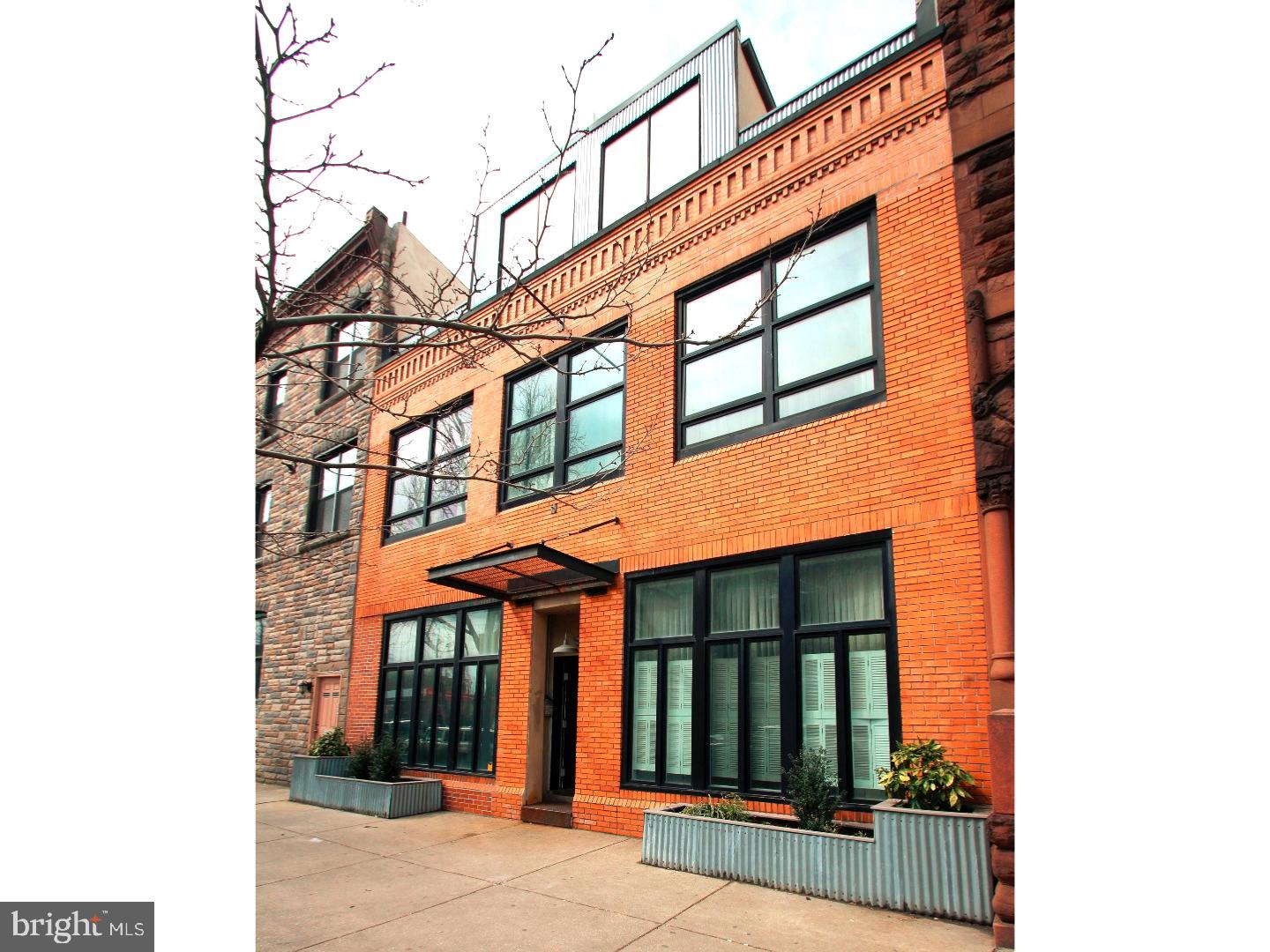 A NEW YORK STYLE LOFT condo that gets every check mark possible! This light filled unit is in "just bring your clothing and furniture" condition. Located in a boutique building, there are only 10 units and this unit is only one of 2 with a pilot house access to a GIGANTIC roof. The unit also has one of the best locations in the building: it gets lots of natural light and is far from the street for zen-like atmosphere. Walk into a very large open floor plan great room with huge kitchen (hardly ever used,) powder room, dining area, and living room. This area has dramatic 12 ft ceilings. View the sunny, ultra-private patio through the wall of windows. Upstairs is an enormous bedroom, also with 12 ft. ceilings, with master bath and elevated area for great storage. The bedroom is large enough to be further sectioned off for another bedroom or office if desired. Continue up one more fight to the pilot house and call your contractor to start designing your roof deck! The roof is constructed of very high grade commercial material ready for a platform and railings. The view is the of the city skyline due north. There are very few condos in the city that have this large of an area for a private deck. Or you can just make a nice, small one, too. In addition there is 1 car GARAGE parking in a well cared for common space that you can enter with a remote for garage door. Pets are welcome. The Broad St. Line Ellsworth Federal stop is steps away and of course, Passyunk Ave. dining is walk-able.