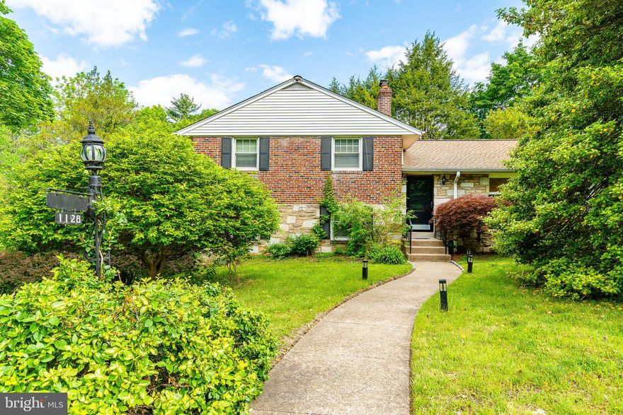 Welcome to 1128 Coventry Rd.! Sitting on a lush corner lot in sought-after Cheltenham, this home features beautiful hardwood floors, oversized windows, and tranquil views of surrounding tree and plant life. Enter your open living area, which can comfortably hold a full family room, office area, and dining space. Your bright kitchen is also on this level, where you'll enjoy updated appliances, and plenty of counter and cabinet space. The split level stairs take you to three large bedrooms (one with a charming en-suite bathroom). Also on this floor is a large bonus closet and modern full bathroom. Downstairs, find a sunny living room with a fireplace, bonus half bath, and extra windows. Exit to your stone patio, which is wonderful for entertaining, relaxing, or grilling. The semi-finished basement is one level further down. Here is laundry, lots of storage, and a convenient slop sink. From here, step into your massive 2 car garage. This property has a brand new roof (March 2025). It's walkable to Cheltenham Elementary, and less than a mile from a Regional Rail stop for quick Center City access. Also nearby are grocery stores (including two H-Marts), countless shops and restaurants, and multiple leafy parks. This home is ready for its new owner - we can't wait to have you come by!