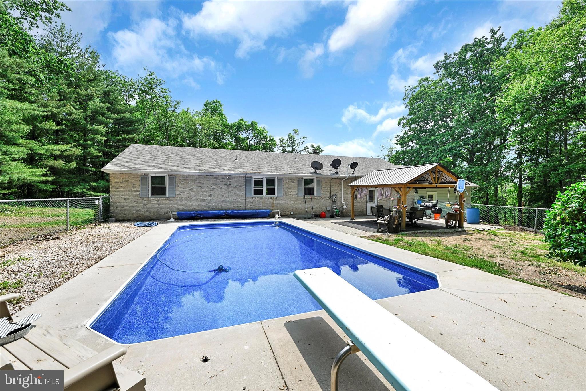 Welcome to your dream home! This magnificent house offers the perfect blend of comfort, charm, and endless possibilities. Nestled on over 3 acres of stunning, partially wooded land, this country oasis provides a serene escape from the hustle and bustle of city life. Step inside and be captivated by the main level bedrooms, offering convenience and easy accessibility. Imagine waking up every morning to the gentle sounds of nature and basking in the abundance of natural light that floods through the windows. Updated with care and attention to detail, this home boasts a brand new roof, new siding, and a new French drain, ensuring your peace of mind and a low maintenance lifestyle. No need to worry about the elements or unexpected surprises—this home is built to last! Prepare delicious meals and create memories in the charming eat-in kitchen, where every culinary adventure becomes a delightful experience. The ample counter space and modern appliances are a chef's dream come true. Transform the bonus room in the basement into your personal sanctuary—an office to fuel your productivity, a playroom to ignite the imagination, or a craft room where creativity knows no bounds. The choice is yours! Discover endless possibilities in the spacious room connecting the garage, currently used as a game room. Whether you envision it as a cozy den, an entertainment haven, or a versatile space for your hobbies, this room will undoubtedly become a cherished gathering spot for family and friends. Step outside into your very own private paradise. Relax and unwind by the inviting saltwater pool, perfect for enjoying lazy summer days or hosting unforgettable poolside parties. Entertain guests under the shade of the picturesque pergola and create lasting memories in this enchanting outdoor oasis. This home is more than just a house—it's a sanctuary where country living meets modern comfort. Don't miss your chance to make it yours. Come and experience the endless possibilities that await in this extraordinary property.