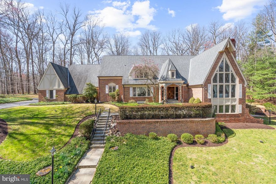 Newly Priced & Ready to Go! Soaring ceilings and light-filled rooms are the hallmark of this spacious 10,000+ square foot home just a few miles from the shops, restaurants, and other amenities of Potomac Village. Located on a beautiful two-acre, wooded lot, this serene and tranquil setting is located in the sought-after Potomac Village Estates neighborhood.
The main level offers a highly desirable two-story primary suite with a loft area perfect for a quiet workspace or library, sitting area, and a fully renovated bathroom with an electric fireplace, two walk-in closets, and an oversized marble shower that can easily accommodate two!
Also located on this level are a large living room with cathedral ceiling, wood-burning fireplace, and two-story wall of windows; dining room; library; and great room that also has a cathedral ceiling and wood-burning fireplace. The kitchen has been renovated to reflect today's active lifestyle with a large center island with pendant lighting and eating space, lots of cabinets with granite countertops, and top-of-the-line appliances. The sliding glass door opens to the back yard with a 1,700 square foot flagstone patio and recirculating fountain, perfect for outdoor relaxation or entertaining.
The upper level provides an abundance of space as well, with four bedrooms and two full bathrooms. One bedroom is adjacent to a sitting room or bonus room with its own staircase to the first floor.
The walkout lower level offers the potential for a variety of living options. A large recreation room boasts a wood-burning fireplace and a curved brick bar with granite countertop that can also serve as an additional kitchen. There is also a bedroom, now being used as a gym, and full bathroom,  a wine cellar, plenty of storage space, 
This fabulous home enjoys easy access to 1-495 and 1-270 as well as Washington, DC and Northern Virginia. Area residents can take advantage of the fine Montgomery County schools in the Winston Churchill Cluster as well as notable private schools. Recreation possibilities abound with a number of nearby public parks and golf courses.