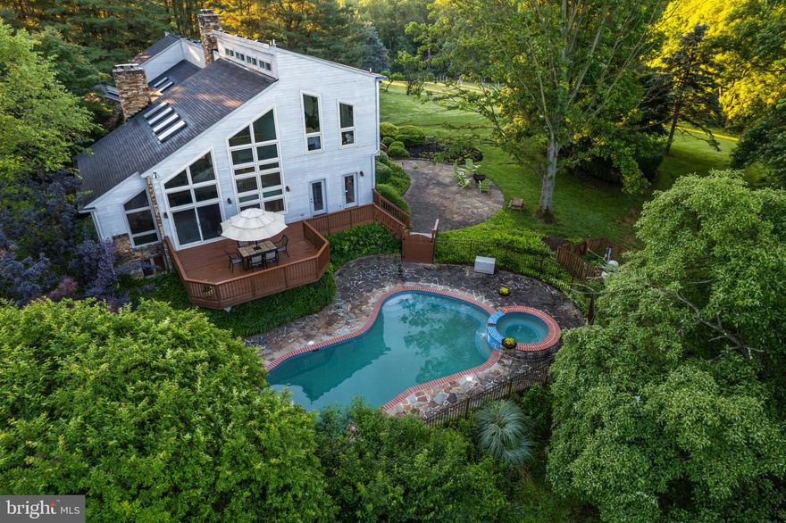 Live authentically. A spectacular contemporary in desirable Hunt Valley. An architectural masterpiece with strong, dramatic lines and walls of glass. A cohesion of stone and wood that creates a sense of serenity. From the moment you pull into the circular drive, you are drawn into a private oasis surrounded by lush hills, woods and unparalleled views. A stunning great room with sky lights, vaulted ceilings and a floor-to-ceiling stone wall with a fireplace beckons you to delight in the natural light throughout. Wake up early for invigorating laps in the pool or watch the sunset and splash under the stars. An expansive flagstone patio leads to the gazebo and fields beyond. 3.96 acres of unending exploration. With beautiful pine plank floors and new carpet on the floating stairs, no detail was overlooked. A chef’s dreams come alive in the spacious kitchen with soapstone counters and stainless steel appliances. One side of a wood-burning stone-stacked fireplace faces the sunlit morning room while the other side warms the sitting room. Entertain in the large dining room that has ample space for gathering with family. The primary bathroom was completely reimagined with an oversized shower, stand-alone tub, sparkling countertops and more. Enjoy the stillness and bathe beside the fireplace in the winter. All bathrooms on the second floor were tastefully updated. Let kids run wild or have space for guests or an au pair in the lower level that has new carpet and a full bathroom. A separate basement entrance welcomes you to an additional play or workout area. A custom study on the main level is the perfect place to quietly work from home. The four-car garage provides abundant room for parking. A location and place to call home unlike any other. Minutes away from Hunt Valley Towne Center, NCR trail, Oregon Ridge Park and more. The art of uniting human and home.