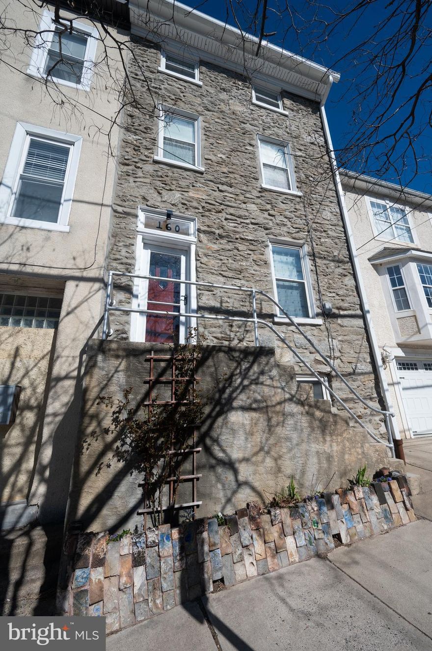 Nestled in the heart of vibrant Manayunk, this  this  one-of-a-kind home is a true work of art, blending historic charm with modern comforts. With original wide plank pine floors throughout, abounding architectural details, an exposed stone wall, modern custom craftsman touches, and central a/c, this home exudes a tranquil warmth with an artistic flare. 

Built on a quintessential Manayunk hill, the home is fronted by a custom flower garden by brick artist, Michael Morgan. Up the stairs and through the front door, you will discover an open and airy straight-through layout. The living room features built-in bookshelves and an abundance of natural light pouring through the south facing front window. The spacious dining room has a gas fireplace with a brick hearth for warmth and ambiance, and original built-in China cabinets. A pass-through window and doorway lead into a country style kitchen with custom Amish-built pine inlay cabinetry and rich cherry countertops, while scenes from the fairy garden entrance and delight through the windows. The laundry area and full bath with curbless shower and custom barn door complete the first floor. Kitchen, laundry area, and bath all have continuous electric radiant floor heat.

Up the original winding stairs, you’ll find one spacious bedroom with two closets and one smaller bedroom with a very large closet big enough for an office buildout or a built-in bed nook. The full bath on the second floor features a cast iron tub, black and white 4x4 wall tiles, and matching keystone floor tiles. Up another winding staircase you'll find another large bedroom with high ceilings and a wide closet, a smaller bedroom with a wide closet, and another full bath with cast iron tub (that's THREE full baths!). 

Outside, escape into your own private fairytale retreat—a magical Fairy Garden complete with a pond, tiered lush landscaping, and custom brick patio area. Whether you're hosting a garden party or enjoying a quiet morning coffee, this backyard is a rare urban sanctuary. 

Located just steps from Main Street Manayunk, you'll have easy access to restaurants, boutiques, cafes, and the scenic Schuylkill River Trail and the stunning views from the Manayunk Bridge. Plus, with convenient access to public transit and major highways, commuting to Center City Philadelphia is a breeze.