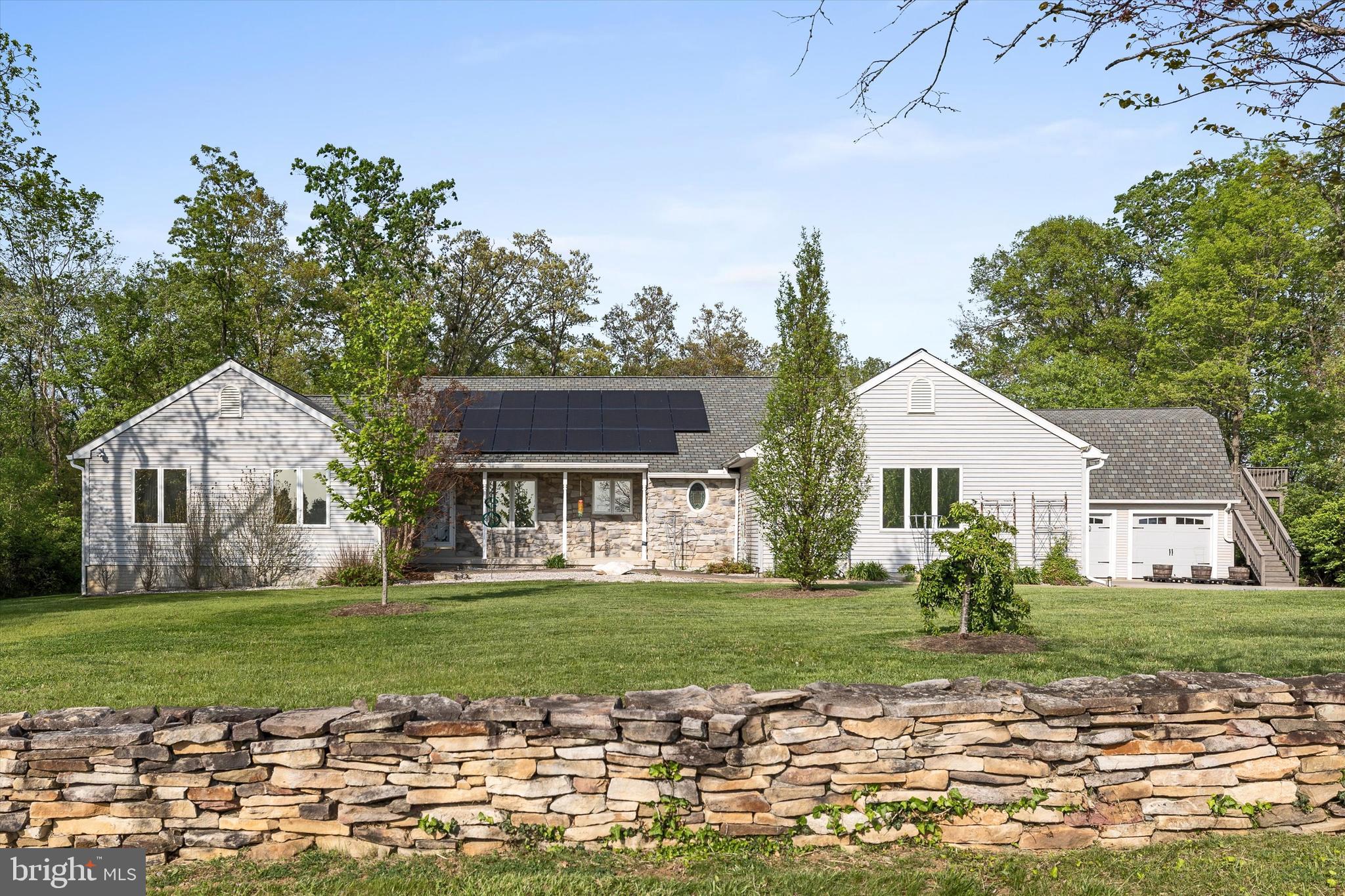 Welcome to your peaceful country oasis. This One level 4 Bedroom, 3.5 Bathroom Ranch Home has it all. Upon arrival the first thing you will notice is the beautiful stone wall that lines the front of the property. Long Concrete driveway to provides plenty of parking and additionally 3 Garage spaces. plenty of room for all of your guests! Lots of mature landscaping with wooded views to the back of the property and farm views in the front. There is a lovely covered front porch on the front to enjoy these wonderful views. Entering the home, you are greeted by Cathedral ceilings in the main living area. To your right you will find the eat in style kitchen with upgraded countertops. Off of the kitchen leads you to the living room that boasts plenty of natural light with sky lights and two double door accesses to the back deck. Wood pellet stove for cozy heating in the colder seasons. There is also a dining area that connects the kitchen and living room that also has its own access to the covered back deck. From there you can head down the hall, on your right you will find a laundry/mudroom with a half bath that also opens to the garage. Further down the hall is a large size bedroom with en suite. On the opposite end of the home, you will find the remaining 3 bedrooms, two secondary and the primary suite. The primary is very good sized with double closets and its own bathroom with tile walk in shower. There is a full bathroom as well for the other bedrooms to share. The home does have solar paneling on the roof which supplements the homes electricity and feeds to the 2 water heaters. Outside of the home is the real selling points. There is a large deck that is partially covered. Good sized cleared area for the back yard which also backs to woods for added privacy. There is a detached oversized 2 car garage. Above that is an apartment that has its own Bedroom area, kitchenette area and full bathroom. This could make a perfect at home office or potential rental idea. If you go back out to Gruber Rd and turn right, you will come to 2 large storage buildings. The first building is a 24x40 with concrete floor. The second building is 30x24 again with concrete floor and this one has an automatic garage door opener on the front. Both buildings have about 10ft of clearance through front doors and both have electricity run to them. These would be perfect shops, equipment storage or etc. This home is a very hard find and will not last long. Call today for Information!
