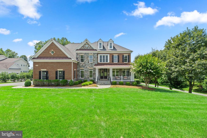 Sited on a private beautiful 1.05 acre homesite in coveted Riverwood you find this stone and brick front colonial offering over 6,875 sqft, a covered front porch entry, a bluestone patio and walkways, a fenced backyard, an extended front porch, entire house music and sound system, a low maintenance deck with integrated lighting, and an irrigation system keeping your lawn lush.
Offering countless luxuries this home has thoughtfully planned entertainment and casual areas that are found throughout this residence featuring elegant touches, exquisite trim, profile crown moldings, and upscale amenities surrounding you with luxury, comfort, and an architectural distinctiveness. A warm welcome awaits when you cross the threshold of this luxury home embodied with elegance and featuring a grand two-story foyer accented by a waterfall staircase and a second level overlook, enriched hardwoods, tray ceilings, and an array of windows with cascades of natural light filling each room with brightness and warmth. Spectacular design throughout the three levels stays running no matter the weather with an emergency backup Generac® whole house generator. An elegant foyer entry introduces this home featuring a spacious formal living room with heightened windows and profile crown molding, a formal dining room accentuated by wainscoting and a ceiling medallion ready for celebratory diners or small intimate gatherings with shining sunlight from a brilliant trio window, and a private study complete with French doors. Entertaining space continues in a gorgeous two-story family room with a marble surround fireplace, amazing natural light from a wall of windows framing a peaceful backyard view and deck, a casual rear staircase, and an ideal flow into the gourmet kitchen followed by a defining sunroom with transom topped windows surrounding the room, a tray ceiling, a designer ceiling fan, and a walkout to the deck with spectacular private thick tree-lined views. Richly appointed and chef ready, the kitchen is equipped with 42” raised panel cabinetry, sleek granite counters, complementing backsplash, a large pantry, an oversized center island with a breakfast bar and pendant lighting, a planning desk, a deluxe line of stainless appliances including a 5-burner gas cooktop, and an open space suitable for a bistro table if desired. Upstairs is designed with three secondary bedrooms and an expansive owner’s suite presenting a tray ceiling, a sitting room, two walk-in closets with custom closet systems, and a deluxe bath showing dual vanities, an oversized shower, and a platform soaking tub. Rich with design elements, the lower level flaunts LVT flooring, a media room with 4K projector and 120” screen, a rec room, a games area, a bedroom, a full bath, extra storage, a exercise room, and a bonus room ideal as a home office. Providing an outdoor entertainment venue and where you can enjoy relaxing evenings watching the sunset is a low maintenance deck, exterior lighting throughout, a lower bluestone patio with custom lighting, and a fenced backyard. The garage offers Epoxy coated flooring, 11 foot ceilings, and a NewAge® Pro series garage storage system that conveys. Experience this hallmark home in a notable Howard County location with beautiful surroundings and a promise of fantastic new memories. Surrounded by expert landscaping and located in one of Howard County’s most desired communities, this relaxing retreat delivers an ideal location for commuting to the Baltimore and Washington metro areas, dining, shopping, golf courses, country clubs, entertainment, airports, and more!