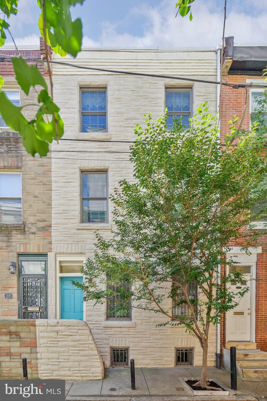 Nestled on a quiet tree-lined block in Philly's sought-after Rittenhouse Square neighborhood, you'll find 1532 Naudain St. This lovingly maintained and updated 3-story home offers 3 bedrooms + a bonus space, 2 full bathrooms, a private patio, and a clean, dry basement. The front exterior features a painted stone facade, a raised entry, and a vibrant door. Inside, you're welcomed by an open and airy main level. At the front is a large kitchen fitted with inset cabinetry, generous counter space, a pantry, stainless steel appliances, and a peninsula with seating. Handsome hardwood floors extend across the bright living room, where there's plenty of space to entertain and a brick fireplace with gas insert for cozy nights in. Out back, the serene garden oasis acts as a retreat from the city's hustle, perfect for barbecues, gardening, and relaxing with a glass of wine. Up on the second level, a bonus space off the stairs is ideal for an office, fitness, or hobbies. At the front, the primary suite has a large bedroom with a pair of bright windows, a walk-in closet, and a modern attached bathroom boasting designer tile floors, a floating vanity, Hansgrohe shower head with rain shower option and a glass-enclosed shower. The top level has a second bedroom and full bathroom off the hall, as well as a huge, sunlit third bedroom. Completing the home is an expansive basement with the laundry and tons of extra storage space. Utilities include central a/c, gas heat, and gas hot water. 1532 Naudain St's unbeatable location earns a perfect Walk Score of 100!  This very special property is located with easy access to the Avenue of the Arts, just a short walk to Rittenhouse Square and close to great restaurants and cultural venues! There's also easy access to public transit, Broad St, Center City, Jefferson University, and Pennsylvania Hospital. Schedule your tour today!