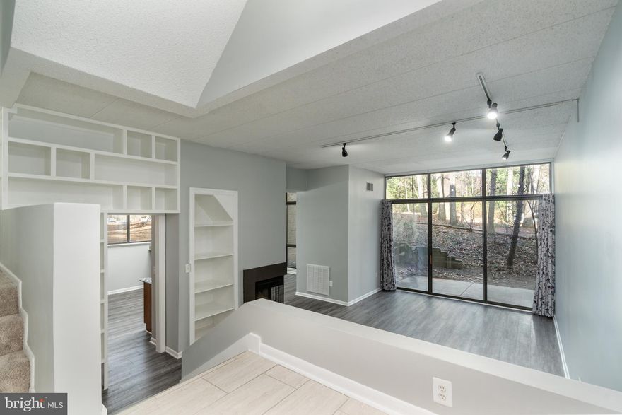 Contemporary Living + Trails + Metro = Reston's Best! Welcome to your completely renovated 1,253 sq. ft., 2 Bedroom, 2 Bath condo at Woodwinds II! The seller left no stone unturned, making sure this end unit is turn-key and ready to be moved-in for its next owner. This unit has impressive 10'+ ceilings and an abundance of natural light flows through the multiple windows. The living room features a cozy fireplace and custom built-in bookcases that add both warmth and character. The kitchen showcases solid wood 42" cabinets with modern lighting and opens directly to a dining area with upgraded fixtures. New luxury vinyl plank flooring spans throughout the living, dining, and kitchen areas, while ceramic tile enhances the entryway. Both bathrooms have been fully remodeled with premium fixtures and finishes. The primary bedroom includes an ensuite bath, and the washer/dryer hookups are conveniently located near the bedrooms. Additional upgrades include new interior doors with modern handles, space-efficient barn-style closet doors, distinctive stair tiling, fresh paint throughout, and all-new electrical switches, outlets, and faceplates. Step outside to your shaded patio for morning coffee or evening relaxation. The condo association covers water, trash, & snow removal services. As a resident, enjoy all Reston Association amenities – outdoor pool, tennis courts, basketball courts, & tot lots. Direct access to Reston's 55+ miles of walking trails puts nature at your fingertips, while being close to Reston Town Center, the Wiehle-Reston East Metro Station, and the Dulles Toll Road makes commuting a breeze!
