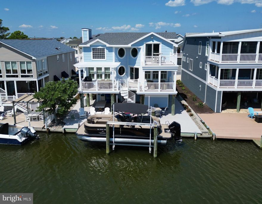 Incredible canal front home just a short walk to the beach with a private dock and boat lift! Take the elevator to the impressive great room featuring soaring ceilings and a combined living room, kitchen, and dining area that opens to a large waterfront porch, creating the ideal layout for entertaining. The gourmet kitchen has been elegantly remodeled and features high end cabinetry and countertops, a beautiful tiled backsplash, stainless steel appliances, and a large center island.  Also on the main floor is the primary bedroom complete with a beautifully remodeled bathroom featuring an over-sized glass enclosed shower and soaking tub.  The upper level offers a spacious loft with a wet bar, 2 beverage fridges and access to a waterside deck.  This area is perfect for fall football games or summer crafts and games for the kids.  Three generously sized bedrooms and 2 full bathrooms are also on this top floor. The ground level foyer offers a large storage room for all of your beach gear, and a laundry room, and opens to a large covered patio deck that extends to the water’s edge. Additional conveniences include a large outdoor shower with changing room, low maintenance features such as HardiPlank siding, composite decking, and no grass to mow! This stunning home is rare find and is offered tastefully furnished and ready to be enjoyed for many summers. Situated on a bulkheaded canal front lot for easy boating access, this is the perfect waterfront location close to the beach yet tucked on a quiet non-thru street within the town limits of Fenwick Island and is just steps from a multitude of local shops and eateries.