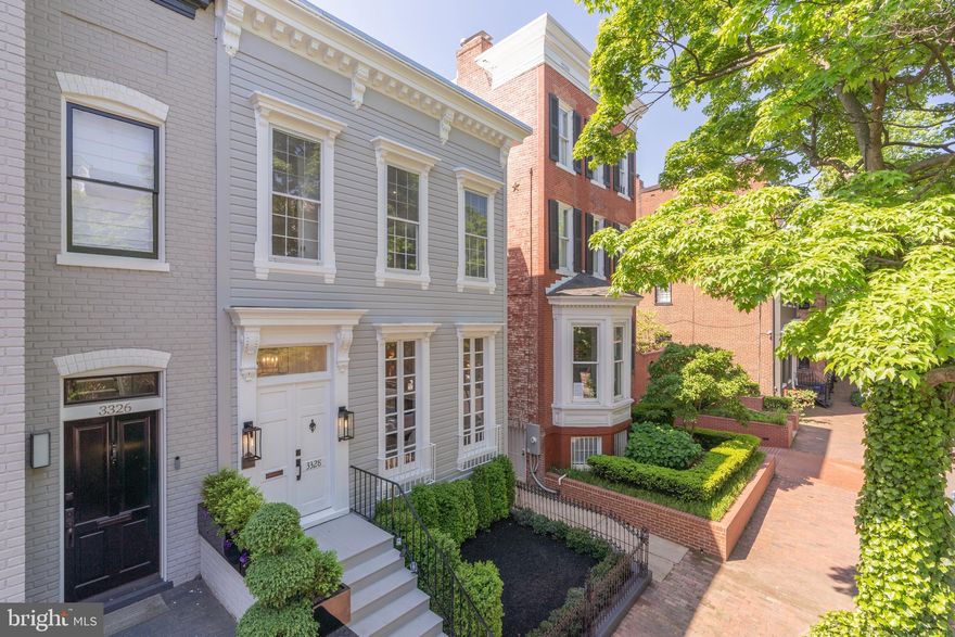 Ideally located in the heart of Georgetown’s prestigious West Village.  Circa 1880 this semi detached home is meticulously renovated top-to-bottom and located on one of Georgetown's most coveted blocks. Featuring a harmonious blend of classic Georgetown architecture and contemporary elegance. Upon entering, you are greeted by the warmth of wide plank, white oak flooring that flows effortlessly throughout the main level, enhancing the spaciousness of each living area. The original, wood-burning fireplace graces the living and is next to the dining room on the main level, perfect for entertaining sophisticated guests. Elegant, custom millwork in the form of paneling and moldings to match the fireplace mantel adds a grandiose finish to these spaces. The chef’s kitchen is a masterpiece of design and functionality, featuring a double-wide kitchen island that has cabinets on both sides, a massive kitchen pantry, and luxurious champagne bronze finishes matching the hardware throughout the home. Off the back room of the home is a  TV room  where you exit to the rear garden.  Escape to serenity in the professionally landscaped rear private yard, an oasis of tranquility beyond the home's rear French doors. The space features a pergola and exotic bamboo landscaping, creating a serene backdrop for gatherings or peaceful moments outdoors. This thoughtfully designed outdoor area ensures a seamless indoor-outdoor living experience. Retreat upstairs to over 1,500 square feet of living space on the second level, where three gracious bedrooms await, with luxurious en-suite baths in all. The primary bedroom is a haven of relaxation, complete with a double skylight that invites natural light to flood the room, creating a bright and airy atmosphere.  There are two large walk-in closets with custom systems throughout. The primary bathroom is a zen-like spa setting with natural stone around and a large soaking tub.  No detail is spared with sconces conveniently integrated into the walls of each bedroom throughout the home.  Conveniently located next to the primary bedroom is the large laundry room equipped with a high-end Samsung washer/dryer system.  The lower level offers versatility and potential with ample space for an in-law suite or rec room, complete with a full bath. With its prime location, timeless appeal, and thoughtful updates, this original Georgetown home is ready to welcome you home. Experience the perfect blend of historic charm and modern luxury, designed for those who seek an exceptional living experience in Washington D.C.’s most desirable neighborhood.  The house is within walking distance to neighborhood restaurants, shops, parks, Georgetown Waterfront, and Kennedy Center.