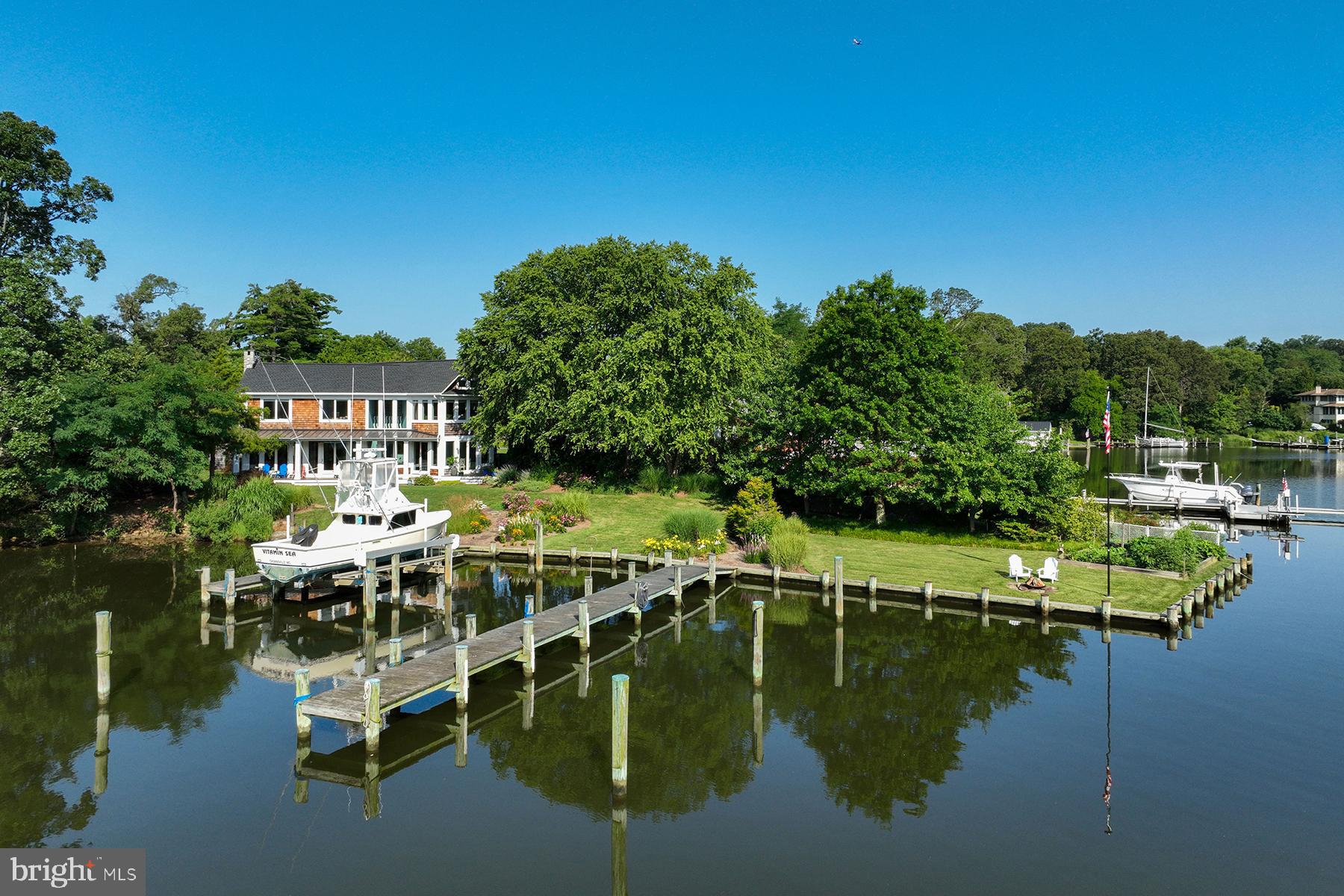 Welcome to 3307 Harness Creek Road-- a Nantucket style, coastal home with spectacular water views, a private backyard oasis and two deep-water piers on protected Harness Creek. This waterside gem, with 190 ft of waterfrontage, is situated directly across from Quiet Waters Park and offers quick access to the South River and the Chesapeake Bay.
Inside, you’re greeted by the natural warmth pouring in from the numerous floor-to-ceiling windows on the main level. The foyer starts a seamless transition to the living room on one side and the kitchen on the other. A central island draped by granite countertops centers the kitchen. Casual and formal dining options make the home great for entertaining. Adjacent to the kitchen is a walk-in pantry with quartz counters, sink and additional storage. The washer and dryer are also conveniently located here.
A cozy sitting area surrounded by bay windows shifts into the main living area. This space features many special details: a wood-burning fireplace, a window seat, and immediate access to the waterside ipe decks. Gorgeous hardwood floors are throughout the house. Closets and a powder room complete the main floor layout.
As you approach the staircase to go upstairs, you’ll notice the beautiful ribbon striped Sapele treads and one-of-a-kind detailing in the railing construction that add another creative touch to this special home. The two-story sitting area brings the natural light into the stairwell. The primary suite includes a spacious bedroom with fabulous Harness Creek and Quiet Waters Park views. The ensuite bathroom has a double-bowl vanity, soaking tub, and oversized shower with glass tile accent. There are two additional water view bedrooms upstairs and an updated hall bath.
On a coveted street close to downtown and providing easy access to Routes 97 and 50, a short walk to the local winery, or a paddle to hiking trails in Quiet Waters Park, this home’s prime location and modern interior make it the perfect combination of boater’s heaven and entertainer’s dream.
One of the best features of this property is the privacy in the lush, waterside yard. Adjacent to the main level living room, there is a spacious ipe wood deck with standing seam metal roof. Relax here and watch the paddlers on Harness Creek and the parade of boats and wildlife. With beautiful landscaping and hardscape, the sumptuous yard adds to the serenity of the waterfront scenery. The two private piers complete with water and electric offer tons of options for the serious boater. One pier is 46 ft and includes a 20,000 lb boat lift, 30/50 amp. electric, fresh water supply and has 5+ ft water depth. The second pier, with fresh water supply, is 76 ft long and can accommodate a sizable sailboat; here, the water is 8 ft at mean low tide. The outdoor spaces and interior detailing work in tandem to create a polished encapsulation of coastal living in Annapolis.
Major system updates include: new two zone high-efficiency 21 SEER Bosch HVAC systems (2024, 2023), treated water for irrigation, sprayed foam insulation in crawl space, new refrigerator, Dacor dual fuel range with propane cooktop, exterior landscape lighting, alarm system, freshly painted interior, new window treatments, and a new roof in 2022.