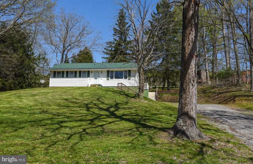 Looking for space to spread out and really live? This 3 bedroom, 2 bathroom rancher sits on 3.6 acres and has everything you need to enjoy country living with all the comforts of home.  Step inside to find a warm and inviting layout ideal for family living. Enjoy cozy mornings and evenings in front of the beautiful stone fireplace— made with local stone. The partially finished basement has a full bathroom, 1–car attached garage,  and lots of potential to expand. Move with peace of mind that the metal roof and central A/C/heat pump are under 10  years old. The expansive land outside offers something for everyone. The oversized 3-car garage is a standout feature—fully equipped with electric and more than enough room for your vehicles, tools, and toys! From your porch-swing, watch the kids enjoy their very own large playhouse, a magical space to explore, imagine, and grow. Pet owners will appreciate the dedicated dog run area, green thumbs will find endless potential with plenty of space to plant a thriving garden and hunters will appreciate that the property is walking distance to public hunting land! Nature is at your fingertips with deer that frequent the property and there is an outbuilding perfect for your chickens!  Whether you’re relaxing under the wide-open skies, working on projects in your garage, or collecting fresh eggs in the morning, this property is more than just a home—it’s a lifestyle. Peaceful, private, and full of potential, this is the countryside retreat you’ve been waiting for.
