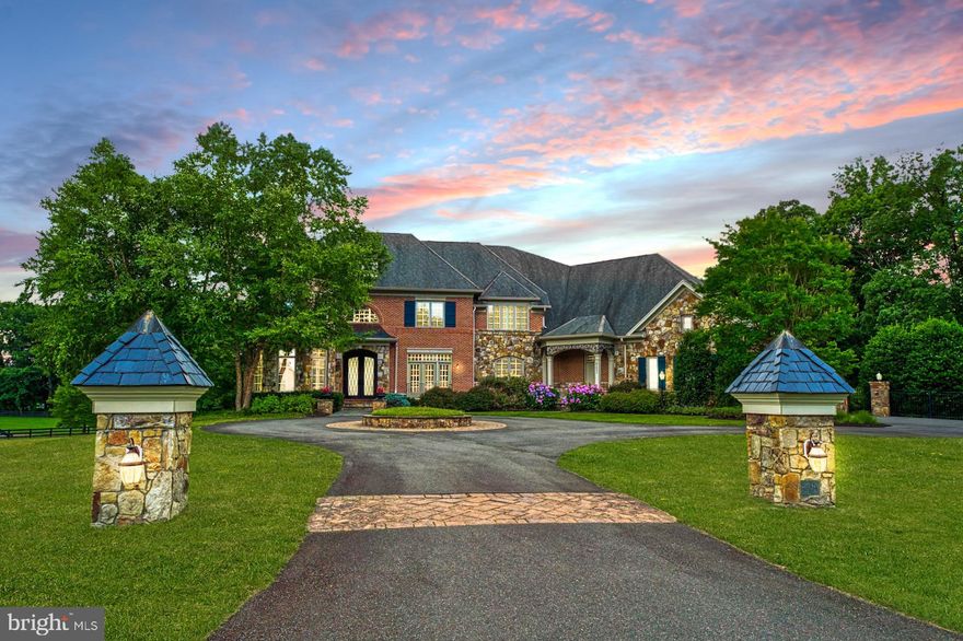 Nestled amongst mature trees within prestigious Grenata, where three-acre grounds feature a lush setting for gathering outdoors, this singular escape enchants as French Country character blends effortlessly with modern sophistication. Arrive home to beautifully crafted construction decked in stone and iron detail, historic-hues, dramatic rooflines, and an idyllic leaded-glass entry. Inside, 8,252 square feet are refined with handsome millwork, cool hues, and glittering fixtures each warmed by sunny transitions, hardwoods, exposed beams, and stately fireplaces. Host gatherings under coffered ceilings lit by view filled transom-topped windows, retreat to relaxed spaces for business, casual visits, or a quiet read, and complete favorite recipes within an inspiring kitchen of provincial personality. While glazed stone-colored cabinetry organizes serving pieces, your chef’s haven is complete with professional-grade appliances, beveled countertops, and a nook for planning the day. Lined by pastoral greenspace and professionally designed gardens, you’ll find privacy for parties on multiple scenic vistas. Serve dinner for a crowd under the sprawling covered deck, take fall drinks to conversation near the open-air fireplace, and let guests linger late as lightscaping, heated-pool, flagstone paths, and water features set a resort-worthy mood. Thoughtfully constructed for everyday life, loved ones will rest and recover within oversized bedrooms with en suite baths. In the primary, choose to stay-in, and let your peaceful refuge soothe with kitchenette, sitting room, dual closets, and graceful bath. While on tour, visit the three-car garage where you’ll tinker with weekend projects and classic cars, then imagine fun in the lower level where you’ll create, exercise, screen movies, and pour glasses of cheer from the bar. Nearby, attend a steeplechase or wine tasting throughout Hunt and Wine Country, while historic townships, commuter routes, favorite shops and eateries, IAD, OneLoudoun, and more offer adventure just moments away.