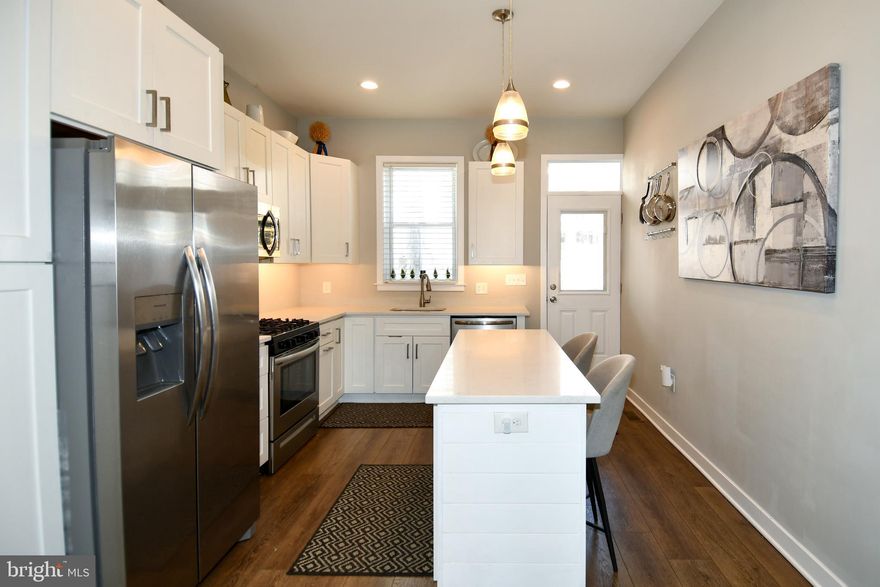 You won't want to miss this opportunity to own a beautiful recently restored end unit rowhome with a new roof and all updated systems in the Upton Gateway Neighborhood . With three thoughtfully designed floors above grade and a full unfinished basement currently set up as a separate level of office space , storage and two queen size bed spaces to allow for extra room for guests. You will enter the home into the light filled oversized living room with an adjacent dining space suitable for a large gathering of friends or family . The Kitchen is appointed with all new top of the line Frigidaire SS appliances an Island with Quartz Countertops and luxury cabinetry complete with 42 inch cabinets and ample space for everything you might need in the kitchen . A half bath compliments the first floor living area. Ascending to the second level you will find two good sized bedrooms with three windows each to allow ample light , one with an en-suite bath and walk-in closet and the other with a large closet space and hallway bath . There is also a dedicated Laundry Room and plenty of space in the hall . On to the top level of the home where you will find the primary suite with its own bath and walk-in closet along with a wall of windows for a light filled space . Adjacent to the primary you will find a sitting room area with access to the fantastic roof top deck area which completes the owners oasis on the top floor. The home has been fitted throughout with custom blinds on every window to ensure privacy when desired . Also outside the home you will have access to a small driveway area and both the public park next door and the dog park across the street . Walk to the Stadiums and the Historic Mount Vernon neighborhood . With everything this home has to offer and quick access to the city and major thoroughfares you will want to make this your first stop !