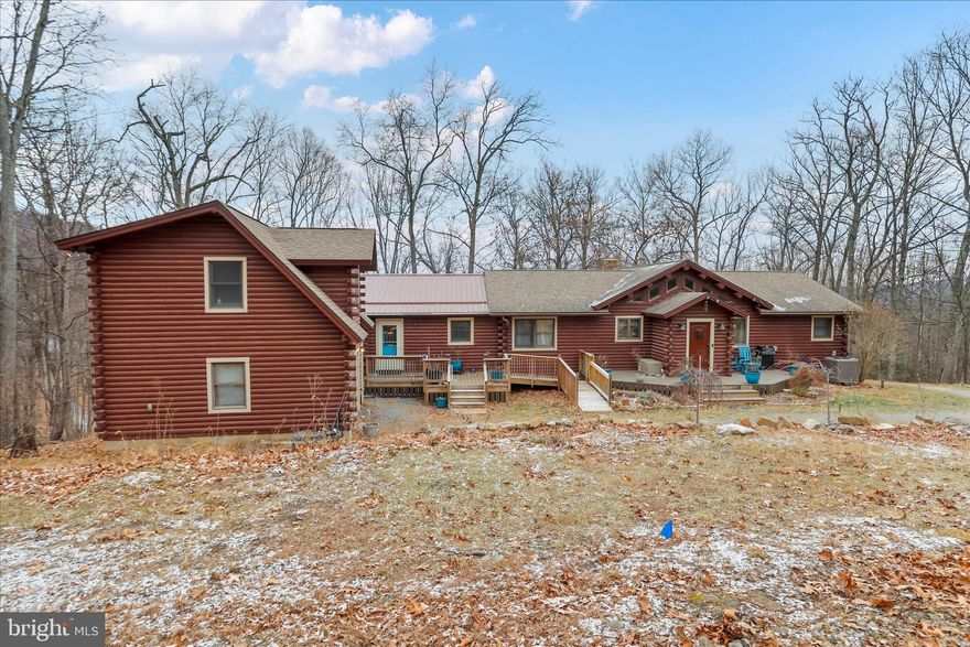 This is a place you own because you want space, privacy, and control—built solid and set apart. On 7 hard-earned acres with mountain views and nothing but woods around you, this 3,584 sq. ft. log home delivers strength, scale, and flexibility that few properties can match. When combined with the detached accessory dwelling, total living space exceeds 4,284 square feet, providing real separation, real privacy, and real options. Heavy timber construction, exposed beams, and tall ceilings aren’t decorative—they’re structural, purposeful, and built to last. This isn’t a cookie-cutter house. It’s a property with backbone. Inside, the layout works the way a real home should. With 6 bedrooms and 4 full bathrooms across multiple levels, there’s room for family, guests, and extended stays without compromise. A substantial addition, purpose-built and previously used as an in-law suite, allows the home to function as a true multigenerational property or be opened up into one seamless, expansive layout. The main living areas are open and functional, filled with natural light, wood finishes, and views that constantly pull the outdoors inside. The land earns its keep. A 700 sq. ft. detached accessory dwelling unit, complete with a living room, kitchen, bedroom, and full bath, adds genuine utility—ideal for guests, extended family, rental income, or a private workspace. A detached one-car garage handles storage and gear, while the acreage gives you room to move, walk the property, and disconnect. Step outside and the noise drops away—no traffic, no neighbors, just woods, wind, and distance. Located in Hampshire County just west of Romney, West Virginia, minutes from the South Branch of the Potomac River and within two hours of Washington, D.C., this property offers true seclusion without isolation. Whether you’re looking for a full-time mountain residence, a multigenerational compound, or a long-term retreat with flexibility built in, this is a property that delivers. Homes like this aren’t built anymore, and they’re rarely offered. When one does come to market, it doesn’t wait for hesitation.