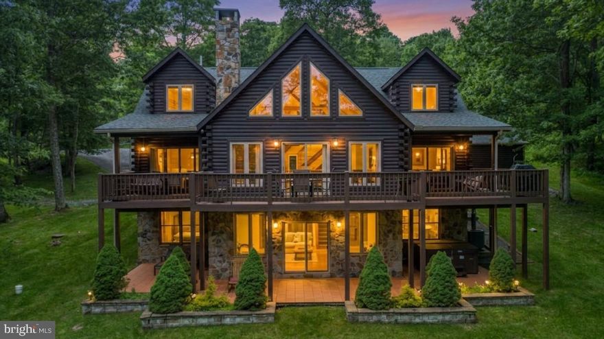 This stunning log home near Wisp Resort offers a luxurious retreat with seasonal views,  an indoor pool house and plenty of space for indoor and  outdoor living.  Five-bedroom, five-and-a-half-bath masterpiece is designed for both relaxation and entertainment. Step inside to discover an open floor plan adorned with exposed beams and rich wood floors. The gourmet kitchen, equipped with high-end appliances including a built-in microwave, wall oven, and cooktop, flows effortlessly into the dining and living areas, perfect for hosting gatherings. Cozy up by one of the two stunning stone fireplaces, or unwind in the fully finished walkout basement, which offers additional living space and direct access to the outdoors. Outside, indulge in your own private oasis featuring a newly upgraded fire pit area overlooking the private 1.46 acre wooded lot. Enjoy breathtaking mountain views and seasonal lake views from the expansive deck or patio, ideal for alfresco dining or morning coffee. Renters and primary residents alike will both love the indoor pool house to enjoy year-round.  Property offers a strong rental history!   With Deep Creek Lake, WISP Ski area and ASCI whitewater course just moments away, outdoor enthusiasts will appreciate year round activities. This property is not just a home; it's a lifestyle of luxury, comfort, and natural beauty. Experience the perfect blend of tranquility and sophistication in this remarkable residence.