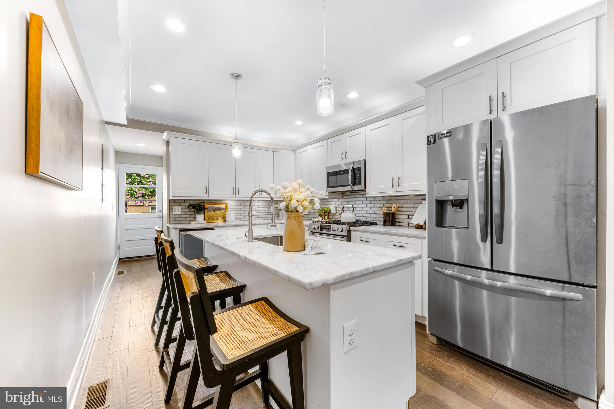 NEW PRICE. Say hello to 3104 Foster Ave, a classic Baltimore row home offering 2 off street parking spots with an A+ location where you can head straight out your door down to Canton Waterfront or up to Patterson Park. This property was fully renovated with CHAP tax credit approval in 2019 - providing roughly 4 years left of insane tax savings. For reference, after the CHAP tax credit is applied for 2025, the tax bill is around $4,957.60 basically 50% less than standard tax bill. MASSIVE SAVINGS. Inside you will immediately notice the classic exposed brick on main level, hardwood floors across main & upper level and a fresh coat of paint. The kitchen is the main event in this house - with a large island with sink & dishwasher, abundance of beautiful white cabinetry, stainless steel appliances, light grey and white granite countertops and gorgeous grey tile backsplash. Continuing past kitchen is a convenient main level 1/2 bathroom and exterior door leading out to an actual fenced in "backyard" / patio and behind the fence, you'll find not 1 parking spot but 2 actual parking spots - this is a rare find in Baltimore City! Upstairs offers 2 bedrooms + 2 full bathrooms, downstairs offer 2 more bedrooms + 1 full bathroom. The upper level hallways has a laundry closet with side by side washer / dryer and hallway door leads to exterior steps to a must have Baltimore City rooftop deck with city skyline views. Come enjoy the fall season in your new home on Foster!