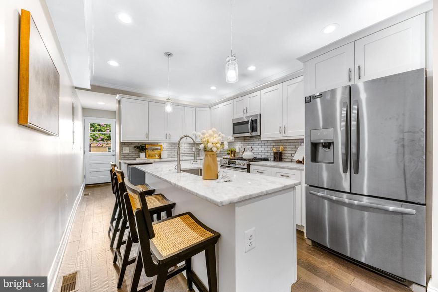 NEW PRICE. Say hello to 3104 Foster Ave, a classic Baltimore row home offering 2 off street parking spots with an A+ location where you can head straight out your door down to Canton Waterfront or up to Patterson Park. This property was fully renovated with CHAP tax credit approval in 2019 - providing roughly 4 years left of insane tax savings. For reference, after the CHAP tax credit is applied for 2025, the tax bill is around $4,957.60 basically 50% less than standard tax bill. MASSIVE SAVINGS. Inside you will immediately notice the classic exposed brick on main level, hardwood floors across main & upper level and a fresh coat of paint. The kitchen is the main event in this house - with a large island with sink & dishwasher, abundance of beautiful white cabinetry, stainless steel appliances, light grey and white granite countertops and gorgeous grey tile backsplash. Continuing past kitchen is a convenient main level 1/2 bathroom and exterior door leading out to an actual fenced in "backyard" / patio and behind the fence, you'll find not 1 parking spot but 2 actual parking spots - this is a rare find in Baltimore City! Upstairs offers 2 bedrooms + 2 full bathrooms, downstairs offer 2 more bedrooms + 1 full bathroom. The upper level hallways has a laundry closet with side by side washer / dryer and hallway door leads to exterior steps to a must have Baltimore City rooftop deck with city skyline views. Come enjoy the fall season in your new home on Foster!