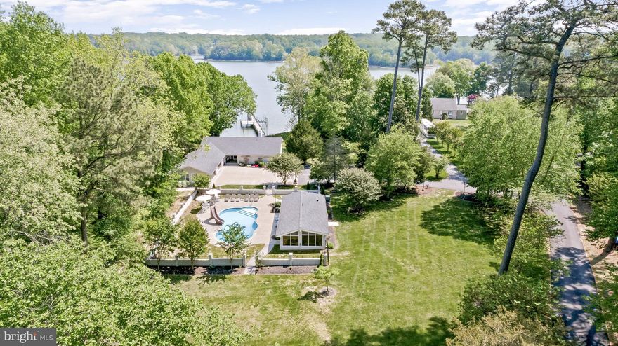 THE FULL PACKAGE!! Offering everything you've ever wanted and more! Welcome to a water lover’s dream—a private retreat situated on 2.16 acres along the serene St. Leonard Creek. This 5000sqft 4-bedroom, 4.5-bath home features an in-ground saltwater pool, a show-stopping pool house, and a 185’ private pier—ideal for those who crave the waterfront lifestyle.

Boaters will love the 60’ x 20’ slip with 12 feet of water depth, 15,000-lb boat lift, two jet ski lifts, electric and water at the pier, and protective riprap shoreline. The grandfathered large pier platform is also an added bonus. Whether you're docking, fishing, or simply enjoying the view, this property delivers.

Enter the home through a charming patio-style entrance. To the left, you’ll find a functional mud/laundry room with sink, storage, and access to the four-car garage. A half bath is conveniently located nearby.

The kitchen is a chef’s delight, boasting upgraded cabinetry, quartz countertops, stainless steel appliances, and sweeping water views. It flows into a massive living room anchored by a wood-burning fireplace with a stunning brick surround and direct access to the stone patio overlooking the creek.

The main level features three generously sized bedrooms, including a luxurious primary suite with expansive water views, and an updated hall bath just off the foyer. The primary suite is quite sizable and comes equipped with a walk-in closet, as well as a well appointed ensuite bathroom with tile floors, a tiled shower, and a single custom vanity with an upgraded vanity top. 

Downstairs, the expansive basement offers an incredible 37x40 flex space, a wet bar with granite countertops, a wood-burning fireplace, a full bath, and a large bedroom with two closets—perfect for guests or multi-generational living.

Step outside to paradise—an awesome pool house featuring a fairly new hot tub, wet bar with full fridge, an ice machine and a serving window—perfect for entertaining. The saltwater liner pool is diving board depth, includes a slide and is the centerpiece of this private outdoor oasis.

Additional features include a whole-house generator, a 59-gallon high efficiency hot water heater, a BAT septic system, and a 4 car attached garage offering even more functionality.

At this price, in this location, with these amenities—this opportunity won’t last. Schedule your private showing today!