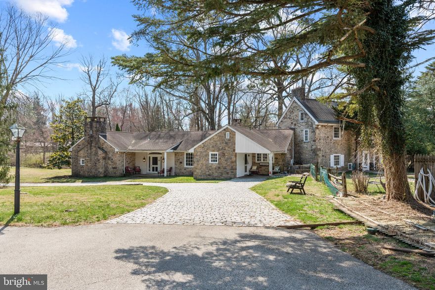 Nestled along one of the most picturesque roads in Huntingdon Valley, this extraordinary estate seamlessly blends historic charm with modern luxury. Set on over three acres with breathtaking views of Huntingdon Valley Country Club, this property offers an unparalleled living experience with expansive living spaces, multiple fireplaces, and unique architectural details throughout.

From the moment you arrive, the stunning 200-year-old farmhouse captivates with its timeless elegance and thoughtfully integrated 21st-century enhancements. Boasting 7 bedrooms and 3.5 bathrooms, this home offers exceptional space and versatility. The first floor features three well-appointed bedrooms and 1.5 bathrooms, providing flexible living arrangements. The primary suite is a private sanctuary, complete with a sitting area, vaulted ceilings, a wood-burning fireplace with a marble surround, and rich hardwood floors. The sunroom is a true showpiece, showcasing soaring ceilings, a striking stone accent wall, bluestone flooring, and expansive windows that invite natural light and frame stunning views of the lush grounds.

At the heart of the home, the chef’s kitchen is a masterpiece. Vaulted ceilings, custom cabinetry, granite countertops, and a Viking six-burner gas stove make this space as functional as it is beautiful. A large island and an open-concept eat-in area create the perfect atmosphere for both everyday meals and entertaining. The great room is simply breathtaking, featuring exposed wood beams, a soaring ceiling, and a massive stone fireplace. French doors lead to a charming brick patio overlooking an expansive lawn and wooded perimeter, offering a peaceful retreat. The original farmhouse layout retains its colonial charm, featuring a formal living room and a tavern room, both with fireplaces. Upstairs, two additional bedrooms, one with its own fireplace, and a full bath maintain the home’s rich history. The lower level is equally impressive, offering two spacious bedrooms, including one with an oversized fireplace, and a full bath to accommodate family or guests.

Beyond the main residence, this estate features several outbuildings, expanding its potential. A two-bedroom carriage house with a full kitchen and bath is perfect for guests or rental income and a five-bay garage . A historic blacksmith barn enhances the property’s unique charm.

With opportunities for multi-generational living, rental income, or even subdivision, this estate presents a rare and valuable offering. A seamless blend of historic authenticity and modern enhancements, this remarkable home must be experienced in person.