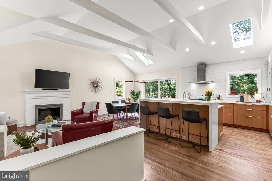 Nestled into Arlington's coveted Cherrydale neighborhood, this mid-Century cottage has been redesigned with a dramatic open floorplan in a sophisticated modern style. Bathed in natural light from vaulted ceilings and two skylights, the main level features rich hardwood floors and a seamless flow designed for elevated  daily life and elegant gatherings. The dazzling gourmet kitchen with high-end appliances and a sleek island that overlooks the spacious living and dining areas that expand outside to a tree-shaded deck. The main-floor primary suite serves as a private retreat boasting a large sitting area, a walk-in closet, and a remodeled luxury bath with a designer walk-in shower. A second generous bedroom and an additional full bath complete the main level. Upstairs, two more bright bedrooms share a remodeled full bathroom. The bright walk-out basement with full height ceiling, includes a big family room and powder room, plus a large unfinished bonus room, offering mulitple possibilities for a home gym, workshop, or additional guest quarters. Recent upgrades include a brand-new roof (2025), new Andersen windows throughout the entire home;  two new mini-splits on upper level (2026), among many other updates.  Outside, the almost quarter-acres property features a lush, tree-lined backyard with several seating areas and deck and is served by a private driveway,  with ample street parking.  Located in well-loved Cherrydale, on a neighborly block,  this home is just steps away from Arlington's network of bike trails and several local parks. Children attend Taylor Elementary and Arlington Science Focus. With a myriad of nearby amenities, quick Metro access, and just 3 stoplights away from D.C., this property offers the best of suburban tranquility and a hip urban lifestyle.