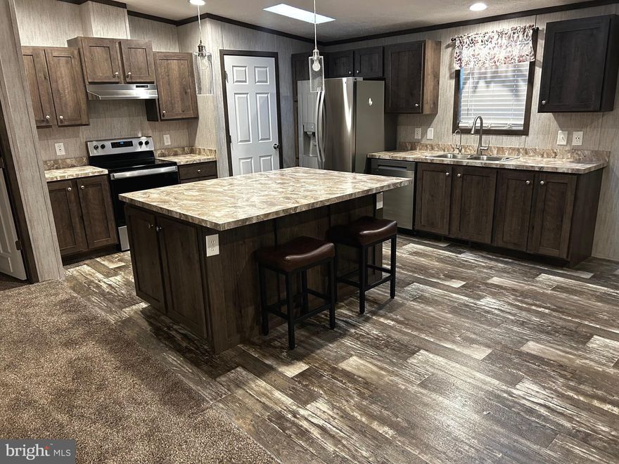 Welcome to this beautifully maintained 2023 double-wide located in a quiet, well-kept neighborhood. This spacious home offers 4 bedrooms and 2 full bathrooms with a bright open-concept layout that seamlessly connects the kitchen, dining area, and large living room—ideal for both everyday living and entertaining. Thoughtful design details include tall ceilings, ample cabinet storage, recessed lighting, and tasteful finishes throughout. The primary suite is generously sized and features a private bath with a walk-in shower and relaxing soaker tub. The laundry room, equipped with a sink, is conveniently located next to the bedrooms and has the added benefit of a water softener. The fourth bedroom provides flexibility and could easily serve as a home office or guest space. Outside, a shed offers additional storage. This home delivers stylish vibes at an affordable price.

Buyer must be approved by the park. Lot rent is $525 per month and does not include utilities. Tax information is ESTIMATED.