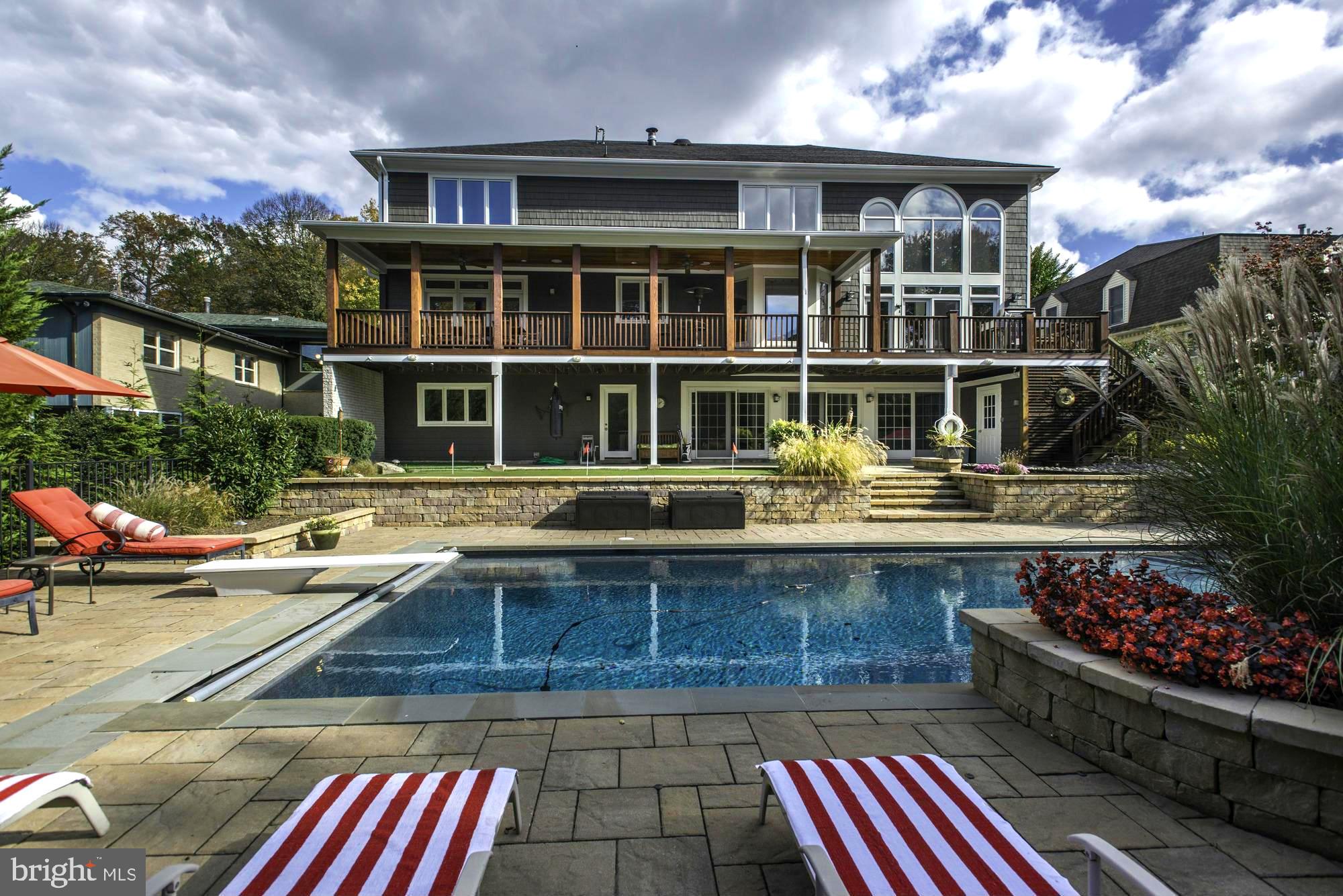 Stunning 5-6BR resort-style residence on magnificently landscaped lot in Kenwood Park! Exquisite rear grounds boasting pool with automatic cover, 3-hole putting green, extensive stone work, and phenomenal covered porch/deck for entertaining. Fabulous main level highlights include a spacious open floor plan starting with gracious 2-story entry foyer, an elegant living room with fireplace, a formal dining room with glass door access to the porch, a gorgeous custom chef's island kitchen open to the 2-story great room with floor-to-ceiling stone fireplace, a large library with built-ins which could serve as a second office or den, a powder room, a walk-in closet/pantry, and a true home office with built-in work station/cabinetry. The wonderful upper level offers a private luxurious owners' wing with adjacent versatile sitting room/office/den, 3 additional ample bedrooms and 2 additional full baths. The bright walk-out lower level features a terrific recreation room with wet bar + glass door access to the rear yard, a professional wine cellar, the 5th bedroom/au pair room next to 4th full bath, a fitness room with closet (could be 6th bedroom), and a laundry room with outdoor access. Extra amenities include surround sound (Sonos), central vac, lawn irrigation system, surveillance system, 2-car garage, semi-circular drive, and more. A DREAM home in every sense of the word!
