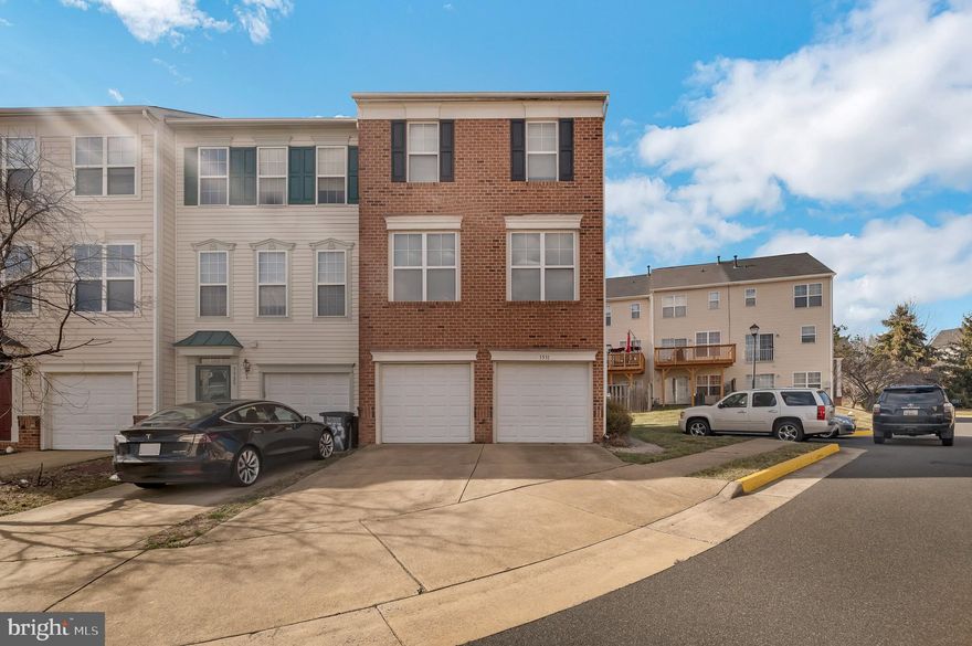 Welcome home to this beautiful brick front Colonial townhome in Prince William Commons! Easy parking with the attached two car garage and paved driveway! Plenty of space for you and your family in this 3 bed, 2 full, 2 half bath home. Enter into a two story foyer that features a convenient coat closet and a hardwood floor landing. Take the carpeted steps up to the main level that includes the living room, dining room kitchen, and half bath. Entertain guests easily in the formal dining room that features crown molding, chair railing, a stunning 5 light chandelier, and plush carpeting that flows into the living room. The spacious eat-in kitchen features tile flooring, plenty of cabinet and counter space, including an island with attached semi-circle breakfast table for everyday meals. Also features double sink with window view, built in workstation, closet pantry, and all stainless steel appliances, including a triple door fridge with ice maker. Carpeted sitting room is the perfect place to unwind with a cup of your favorite warm beverage and has easy access to the sliding glass doors leading to the upper level open air deck. Half bath completes the level. Take the stairs to the uppermost level and main bedroom suite that features vaulted ceiling, cooling ceiling fan, plush carpeting and large closet. Also features an en-suite bathroom with dual sink vanity and tub/shower combo. Two bedrooms, both with plush carpeting, and a hall bath complete the level. Relax in the family room on the lower level that features large windows and plush carpeting. Stay warm and cozy next to your wood burning fireplace that also features a mantel enclave just the right size for your tv! Half bath completes the level. Take the sliding glass door to your fully fenced in backyard! Walking distance from shopping centers and close to multiple dining destinations, plus easy access to 95. Do not miss out on this one!