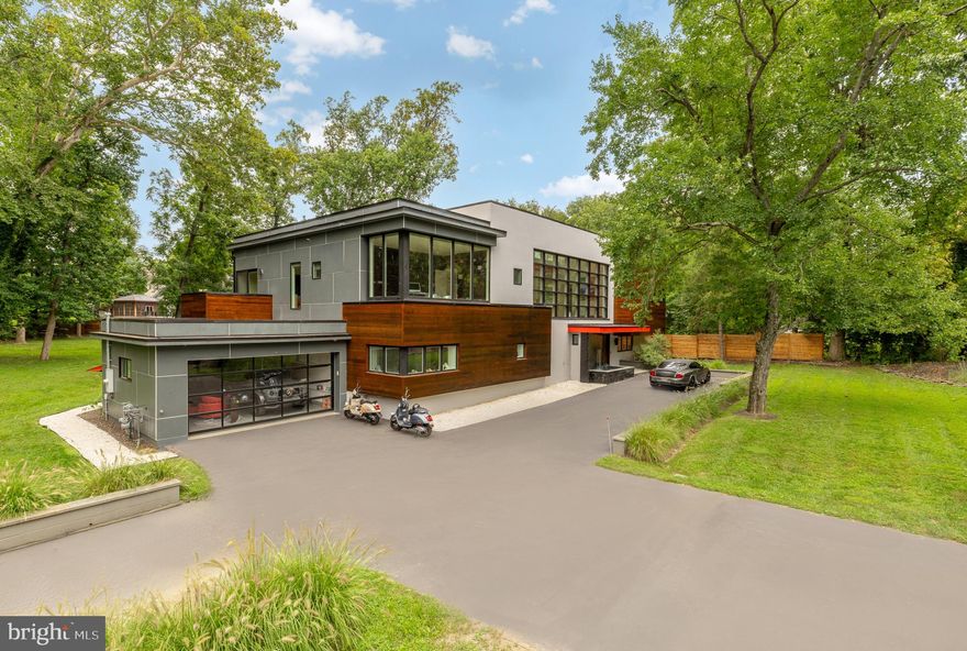 Striking modern architecture and refined luxury come together in this exceptional contemporary residence, set on over ONE ACRE of rare, private land just moments from downtown Bethesda, an extraordinarily hard-to-find combination of scale, privacy, and proximity.

Defined by clean lines, expansive windows, and warm architectural materials, the home blends modern design with its natural surroundings, creating a private retreat that feels both sophisticated and serene. Recently reimagined with a thoughtfully updated layout and beautifully renovated baths, the residence spans over 5,400 square feet of light-filled living space designed for effortless everyday living and elevated entertaining.

Inside, the home showcases rich hardwood flooring throughout the upper level and sleek modern tile on the main level, reinforcing a thoughtful balance of warmth and contemporary style. Soaring ceilings and oversized windows bring in abundant natural light while maintaining privacy throughout. Designer finishes, motorized shades, and a Savant smart-home system enhance the home’s modern functionality without sacrificing comfort.

The gourmet kitchen anchors the main living level, offering generous prep space, high-end finishes, and exceptional pantry and storage capacity—an uncommon luxury in modern homes—featuring Sub-Zero and Wolf appliances designed for both serious cooking and seamless entertaining. Open living and dining areas flow effortlessly to the outdoors, creating a layout equally suited for intimate evenings or large-scale gatherings.

The upper level features four spacious bedrooms and four beautifully updated full baths, including a luxurious primary suite designed as a true private retreat. The primary suite opens to a private balcony and features a spa-inspired bath with a soaking tub, steam shower, double vanities, a private water closet, and thoughtfully designed architectural and ambient lighting that elevates the experience from day to night. Secondary bathrooms are all well-appointed and recently redone, featuring a soaking tub and sleek tiled showers with modern finishes throughout.

The main level includes an additional bedroom and full bath, ideal for guests, an office suite, or flexible living arrangements.

Outdoors, the property unfolds into a true resort-style sanctuary. A dramatic front-entry fountain sets the tone on arrival, while the expansive rear patio, lush privacy, and stunning pool with an electronic cover create an outdoor oasis rarely found so close to downtown Bethesda. Whether hosting poolside gatherings, enjoying quiet mornings surrounded by nature, or unwinding at the end of the day, the setting offers a level of space and tranquility that is nearly impossible to replicate.

Additional highlights include a garage with a striking glass-panel door, abundant storage throughout, and a location that delivers the best of both worlds: over an acre of land with immediate access to Bethesda Row, dining, shopping, and Metro.

Why go to a hotel when you can go home.
PRIVATE RESIDENCE — BY APPOINTMENT ONLY