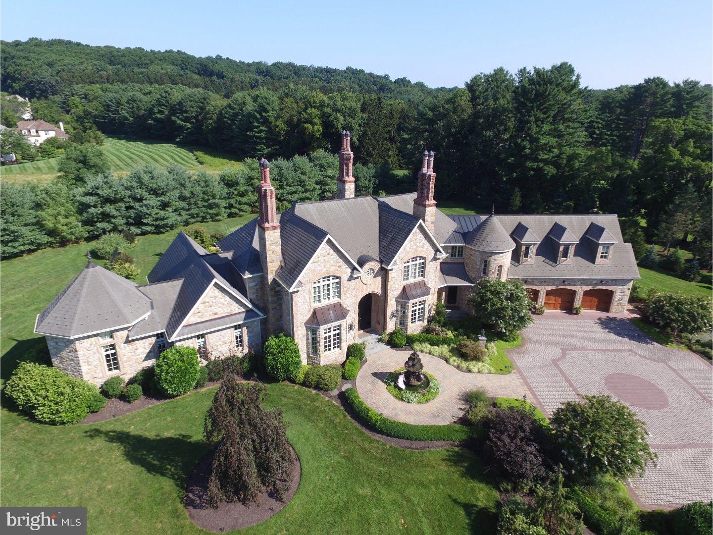 This "storybook castle" located in Solebury Township, is close to Peddler's Village and stands out amongst all others as one of the most impressive houses in Bucks County. Situated on over 9.7 acres with it's towering chimneys, natural stone facade and thoughtful landscaping,this is an estate like no other! Originally designed and constructed by D'Alessio Inspired Architectural Designs, it was aptly named Maison de Village ("Village House"). Built of castle cut-stone and old-world limestone plaster this home will stand the test of time. The interior of this magnificent home has the same stellar craftsmanship as the exterior. From three Rumford fireplaces, white oak flooring, plaster walls, custom cabinetry, exquisite finished walk-out lower level and backyard oasis, this home is truly a masterpiece. Highlights are a first-floor Master Suite with a luxurious master bath and a beautiful gourmet kitchen with custom cabinets, Wolf & Sub-Zero appliances and center island with breakfast room. The walk-out basement is more aptly called the "Entertainment Level" and boasts a 1,000 bottle wine cellar, gym,game room with custom seating banquette and the state of the art home theater with fully automated controls is a movie lovers dream! The fenced back yard includes a large free form swimming pool with a waterfall and spa. There is plenty of stone patio surface for backyard BBQ's around the granite topped summer kitchen with Viking gas grill, bar and pizza oven. Meticulous landscaping includes irrigation zones and 8'foot tall deer fencing. This amazing 5 bedroom home also has an oversized 3-car garage and over 8,000 square feet. This is an opportunity to own a once in a lifetime property!