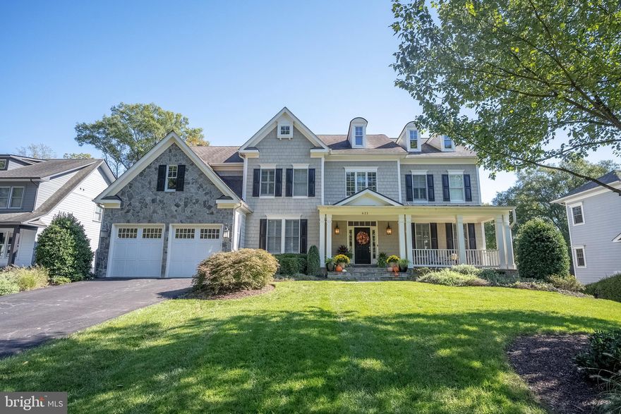 Nestled in the heart of Vienna, just two blocks from the vibrant shops and restaurants of Maple Avenue, this beautifully remodeled Craftsman home offers a rare opportunity to own a piece of serenity on a quiet cul-de-sac.  Set on a generous 0.51-acre lot, the home’s stone and shingle façade, accented by architectural dormers, exudes timeless charm.  A flagstone walkway leads through the meticulously landscaped front yard to an expansive front porch, perfect for relaxed seating.  Step inside to a welcoming foyer with a grand sweeping staircase, flanked by a refined front office with custom built-ins and an elegant living room featuring a gas fireplace with a marble surround.  Rich hardwood floors, crown molding, and plantation shutters grace the main level, flowing seamlessly into the formal dining room, where chair rail and shadow box molding create a sophisticated ambiance.  The heart of the home is the luxurious kitchen, fully remodeled in 2020.  Designed with the discerning chef in mind, this space features custom solid wood cabinetry by Plato Woodwork, topped with stunning Calacatta Nuvo quartz countertops and accented by polished nickel hardware.  The honed paperwhite and polished Calacatta mosaic backsplash adds a touch of artistry, while professional-grade appliances, including a 48” Wolf range with six burners and griddle, Wolf range hood, two Asko dishwashers, and Sub-Zero paneled refrigerator and freezer, ensure culinary excellence.  A spacious center island with breakfast bar seating and a hidden pantry behind a seamless cabinet design enhance the functionality and style of this chef's dream.  Accordion doors in the breakfast area allow for seamless indoor-outdoor living, opening onto the outdoor deck and covered porch.  On the upper level, hardwood floors extend into the hall and loft area, which is adorned with custom built-ins and a bench.  The primary suite is a private sanctuary, featuring a sitting room with a gas fireplace, two custom walk-in closets, and a spa-like primary bath.  The bath is a tranquil oasis, complete with two oversized vanities, a soaking tub, and a walk-in shower with floor-to-ceiling ceramic tile.  Bedrooms two and three share a thoughtfully designed buddy bath, while bedroom four enjoys an en-suite bath with modern fixtures.  The expansive second upper level is an unfinished canvas, offering endless possibilities for future expansion into a bonus room, bedroom, or additional living space.  The fully finished walk-out lower level, remodeled in 2022, with the finest materials, features hardwood-style LVP flooring and a modern kitchenette/bar with black cabinetry, Calacatta countertops and backsplash, full-size wine fridge, and paneled appliances. This level offers a spacious recreation room, game room, exercise room with pocket doors, a full bath, and a fifth bedroom, making it perfect for guests or extended family.  Outdoors, the covered rear porch is an entertainer’s dream, boasting a tongue-and-groove wood ceiling, radiant heating, and a stone fireplace with commanding views of the expansive, fully fenced backyard. Trex deck flooring (2024). A concrete patio and lush, mature landscaping create ample space for play, relaxation, or outdoor gatherings.  This home is an exceptional offering in a prime location, blending luxury, comfort, and timeless appeal.