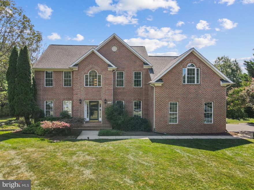 Welcome to 16009 Fields End Ct, Woodbine, MD 21797 – a stunning brick-front colonial on a private 1+ acre lot in the desirable Warfields Grant community, with NO HOA! This beautifully refreshed 4-bedroom, 2-bathroom home offers over 3,000 sq ft of finished living space and 1,500+ sq ft of unfinished basement with walk-up access, ready for your personal touch.

Freshly updated with new carpet, fresh paint, and modern lighting, this home is move-in ready and shines with warmth and style. A dramatic two-story foyer and elegant oak staircasewelcome you in. The sun-drenched formal living and dining rooms flow effortlessly and feature large windows, crown molding, chair rail, and a tray ceiling, creating the perfect ambiance for entertaining.

The expansive kitchen is a chef’s dream with tons of cabinet space, center island with cooktop, double wall ovens, and built-in desk area, all overlooking a picturesque backyard through oversized windows. A sunroom-style bump-out connects the kitchen to the show-stopping two-tier deck, freshly stained and perfect for entertaining, grilling, or relaxing under the stars.

The family room boasts soaring vaulted ceilings, oversized windows, and a dramatic floor-to-ceiling brick fireplace with a herringbone inlay—ideal for cozy evenings. Upstairs, retreat to the massive primary suite with cathedral ceilings, a private sitting area, oversized windows, and a spacious en suite bath featuring a soaking tub, dual vanities, separate shower, and private water closet. Three more well-sized bedrooms complete the upper level.

Downstairs, the full unfinished basement offers over 1,500 sq ft of potential: gym, rec room, theater—your imagination is the limit.

Additional highlights include:
- New carpet and paint throughout
- Updated light fixtures for a modern feel
- Professionally landscaped yard with mature trees and curb appeal
- Flat, usable backyard with over an acre of privacy
- Two-car side-entry garage with inside access and ample driveway parking
- Backup generator (as-is) and water neutralizer system
- Well water and on-site septic (no water/sewer bills!)

Ideally located in a quiet cul-de-sac in a rural setting that still offers quick access to major commuter routes and shopping. Zoned for top-rated Bushy Park Elementary, Glenwood Middle, and Glenelg High School.

This home truly offers the best of both worlds—refined interior spaces, generous outdoor living, and the peace of mind that comes with modern updates in a mature, sought-after neighborhood.

Don’t miss your chance to make this impressive home your own—schedule your private showing today!