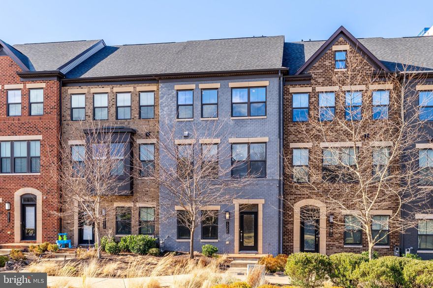 Welcome to 13208 Woodland Park Road — a stunning 2018 townhome offering four beautifully finished levels of modern living in the heart of Herndon.  The entry level features a versatile bedroom and half bath, perfect for a guest suite, home office, or gym. The main level impresses with on-trend hardwood floors and solid oak stairs connecting all four levels. The gourmet kitchen with balcony is a true showstopper, showcasing white shaker cabinetry, quartz countertops, a large grey cabinetry island with seating, stainless steel appliances, and a stylish designer backsplash. The open layout flows seamlessly into a spacious family room with cozy gas fireplace — large enough for a sectional and extra seating—and a bright extended dining area, creating the perfect setting for relaxing or entertaining.   Don't miss the convenient balcony off the family room with scenic pond view.

Upstairs, the third level features three bedrooms and two full bathrooms, including a serene primary suite with a spa-inspired ensuite bathroom offering a Roman shower, double-sink vanity, and walk-in closet. Two secondary bedrooms share another beautifully upgraded hall bath.

The fourth level retreat continues to impress with a large recreation room, full bathroom, and access to a private rooftop deck overlooking the community pond—perfect for entertaining or unwinding most of the year.  East-facing and flooded with natural light with an abundance of windows, this home feels warm and inviting throughout, enhanced by premium window blinds that add both style and functionality. Every detail feels straight out of HGTV.

Located in a sought-after neighborhood, and districted to the new state-of-the-art FCPS western high school, this home offers walkable convenience to supermarkets, restaurants, coffee shops, and a large park with athletic fields and playgrounds. Just one mile from both the Herndon and Innovation Center Metro stations, plus easy access to major routes, this is an exceptional opportunity to enjoy modern comfort in a vibrant, connected community.

The new western high school campus is thoughtfully designed to inspire learning, creativity, and community at every level. From innovative classrooms and collaborative learning pods to state-of-the-art performance and athletic facilities, each space reflects a commitment to excellence and engagement. 

Additional highlights include a two-car garage, tankless hot water hear, whole house humidifier, Nest thermostat, and Nest front and rear security cameras.