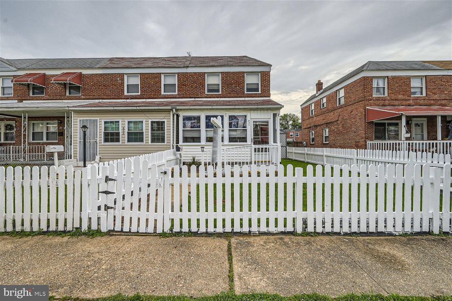 An adorable white picket fence surrounds the yard of this end-of-row 3BR/1BA end-of-row townhome on a quiet street.  Step through the fence and walk past a lush green lawn, and open the door into your forever home.  The first room is an enclosed porch surrounded by windows and the door into the main living space.  The living room boasts gleaming hardwood floors and a decorate fireplace surrounded by a brick hearth.  Step through into the large eat-in kitchen featuring plenty of cabinets to the ceiling finished with crown moldings, newer appliances, plenty of counter space with a custom backsplash, a coffee/serving station, and plenty of room for a breakfast table.  Tucked behind the kitchen is a spacious family room with access to the fenced yard.  Hardwood flooring can be found in all rooms on the second floor boasting a spacious primary bedroom, two sizable secondary bedrooms, and a full bath.  The lower level offers additional living space, storage, and laundry.  The yard boasts an abundance of green space ideal when hosting family and friends.  This home is move-in ready with so much to offer new homeowners.  Imagine all this and is located in close proximity to shopping, restaurants, and commuter routes.