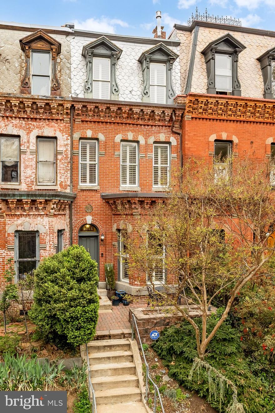Perched along a picturesque, tree-lined street in the heart of Dupont Circle, this classic Victorian rowhome sits at the epicenter of DC living. Rich in historic character and thoughtfully updated throughout, this residence captures the essence of Washington living, complete with a private outdoor oasis, rare two-car garage parking, and effortless access to the very best of city life. Step inside to a light-filled living room anchored by a gas fireplace, where hardwood floors and original details create a warm, refined first impression. The home unfolds naturally from there, with a dedicated dining room and a well-designed kitchen at the rear featuring premium appliances, a peninsula island, wine storage, and a timeless mix of wood and light cabinetry. Adjacent is a space ideal as a breakfast nook or banquette, adding flexibility for everyday living. Just beyond, a private rear deck with lattice fencing offers a true outdoor retreat, ideal for entertaining or quiet mornings and evenings at home. A powder room completes the main level.

The second level is anchored by a spacious primary suite with hardwood floors, a tray ceiling, and a Juliet balcony overlooking the rear deck. A walk-in closet and a well-appointed bath with a double vanity, standing shower, and clawfoot tub with spa features complete the space. At the front of the home, a second bedroom with a gas fireplace and exposed brick is currently styled as a sitting room, adding both character and versatility. A full hall bath and laundry are also conveniently located on this level. Upstairs, the top floor offers a private suite with a full bath and a walk-in closet that has been thoughtfully built out with a dedicated office area, creating an ideal guest space or work-from-home setup. The lower level is currently used as an office and offers flexible space for a gym, additional living area, or wine storage. It also has direct access to a rare two-car garage, an exceptional amenity in this sought-after location.

Just outside your door, experience the best of Dupont Circle living with immediate access to the iconic Dupont Circle Park, the Metro, and some of the city’s most renowned restaurants, cafés, and shops. Within minutes, you can reach Georgetown, Foggy Bottom, and Kalorama, along with major institutions including George Washington University, the World Bank, and the International Monetary Fund, placing you at the center of both city living and global connectivity. A rare opportunity to own a thoughtfully updated Victorian in one of Washington’s most connected and sought-after neighborhoods.