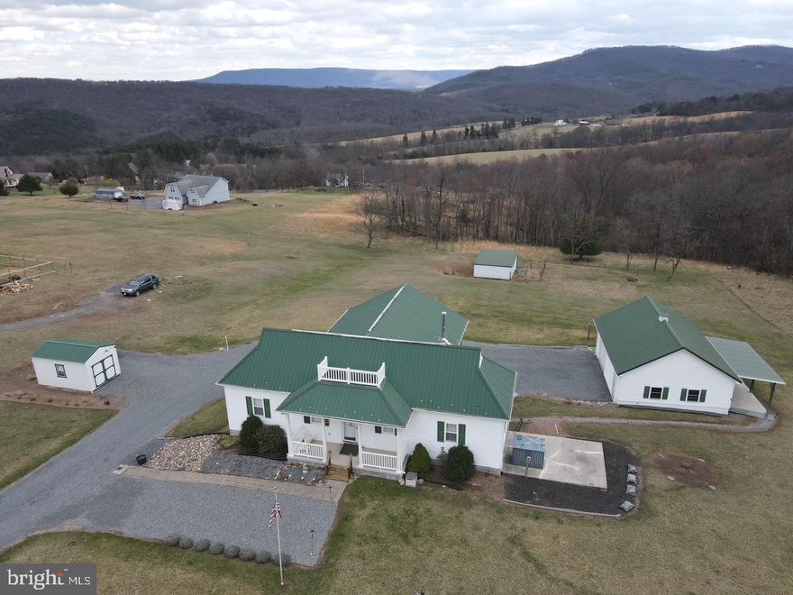 Call today to see this spacious 3 level home, that shows pride of ownership with a partially finished basement located just outside of Romney. The home has a welcoming foyer area and the main floor features vaulted ceiling and beautiful wood floors. You will love the natural light that just pours in from the large window in the country style eat-in kitchen. On those cool days and evenings, you will find yourself cozing up in the living room with the warmth from the wood stove with a stone firewall accent. This home has 3 bedrooms and 2.5 bathrooms. The primary bedroom is on the main floor and has an ensuite bathroom with a tub/shower and a separate walk-in shower. The second bedroom is also on the  main floor. The loft  is currently being used as a 3rd bedroom, but this functional space has endless possibilities. With a closet and it's own bathroom, you can continue to use the loft as a 3rd bedroom, or you can create a wonderful reading area, make it a home office, or anything you wish! The basement is partially finished with a nice den area and a summer kitchen! Parking isn't an issue with the lower level 2 car attached garage and the oversized detached 1 car garage/workshop. There is also plenty of area for parking in the gravel driveway. The 2 acre lot is mostly level and completely usable! You can enjoy your beautiful yard while  taking in the panoramic views of the mountains. This home is a convenient 5 mile drive to the heart of downtown Romney and about 6 miles from the South Branch of Potomac River. You are a quick 10 minute drive to shopping, dining and banking. Romney, WV is about a 45 minute drive to Winchester, VA and to Cumberland, MD.