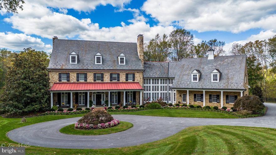 Celebrate the season with a new price on this beautiful home. Your perfect holiday gift to yourself! Nestled on nearly 13 acres in the heart of historic My Lady’s Manor in Monkton, 1912 Corbridge Lane has been described as one of the most beautiful homes and properties in Maryland, with a design by architect Joanne Moncure, AIA and meticulously brought to life by custom home builder, Jeff Duerbeck. This remarkable Manor Home with a Butler Stone exterior and slate roof spans four levels, designed to combine historic charm with modern elegance in 12,000 square feet of luxurious living space. The spectacular views and stunning outdoor areas include an onsite hiking trail, a stocked pond, and over 700 feet of coveted frontage on the Gunpowder Falls River.
Upon entering the foyer, your eyes are immediately drawn to the soaring windows and the impressive wood and wrought iron spiral staircase. The Great Room offers a vaulted coffered ceiling, a Butler Stone wood burning fireplace and custom built-in cabinetry with adjacent French doors leading to a large, covered veranda. The Dining Room is the perfect place for lavish entertaining and includes a wood burning fireplace and French doors leading to a covered front porch.
The incredible Chef’s Kitchen was designed with entertaining in mind. An expansive Quartzite center island and counters, custom cabinetry, Wolf 6 burner gas range, two dishwashers, three ovens and two wood paneled refrigerators adorn this impeccable space. A Breakfast Room has a built-in banquette seating and sliders leading to a large screened in porch with scenic views. There is also a rear staircase leading to the upper levels.
The second level boasts five bedrooms including a large Primary Suite with French doors off the bedroom leading to a rear porch which offers breathtaking views of the pond and the Gunpowder. The Primary bath has Travertine flooring, an oversized jetted tub, large walk-in shower, his/her vanities, and oversized walk-in closets. Four additional spacious bedrooms including a Guest/Au Pair/In-law Suite which also includes a living room, kitchenette, and full bathroom.
The lower-level Irish Pub features a Media Room, Wine Cellar, custom crafted bar, billiard room, and a walk-out leading to the pool area. The heated in-ground pool is surrounded by lush landscaping, waterfall spa, lounge areas and pavilion that provides a tranquil retreat.
Enjoy hiking, biking, fishing, kayaking, local wineries, breweries and more, all set within one of Baltimore County’s most idyllic neighborhoods. This is a one-of-a-kind estate property. Please make an appointment to experience this magnificent property.