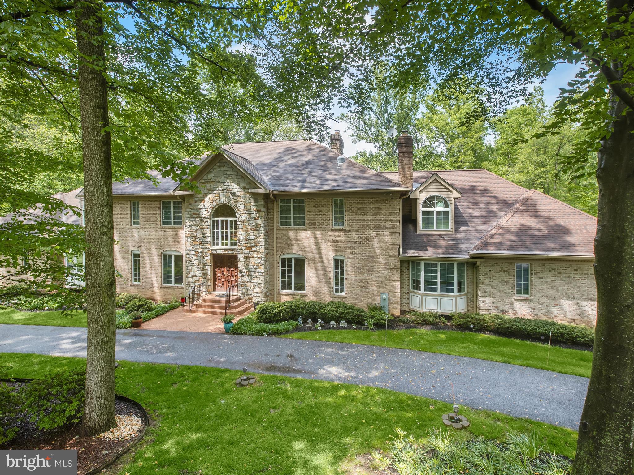 Welcome to this extraordinary estate nestled in the prestigious Hill Farm community of Lutherville-Timonium, where luxury, timeless elegance, and exceptional design converge. This multigenerational masterpiece offers a rare blend of sophistication, space, and versatility, perfect for extended family living. A grand foyer sets the tone for refined living with ceramic tile flooring, soaring ceilings, intricate double front doors, a dramatic Palladian window, elegant crown molding, and statement lighting. The formal living room exudes classic charm with gleaming hardwood floors, a wood-burning fireplace framed by built-in display bookcases, and floor-to-ceiling windows that fill the space with natural light. Host unforgettable gatherings in the formal dining room, beautifully appointed with crown molding, chair railing, box wainscoting, and rich hardwoods. The heart of the home is the gourmet kitchen, thoughtfully designed with a center island and breakfast bar, planning station, stylish backsplash, stainless steel appliances, and a sun-drenched breakfast area. Open to the kitchen is a breathtaking two-story family room featuring hardwood floors, a dramatic stone-surround wood-burning fireplace, wet bar, and direct access to the expansive deck, ideal for seamless indoor-outdoor entertaining. A spacious main-level guest wing enhances the home’s multigenerational appeal, offering a private living and kitchen combination complete with granite counters, center island, 42” soft-close cabinetry, stainless steel appliances, and bay window seating. The private bedroom suite includes plush carpet, three closets (including two walk-ins), and a luxurious bath with a double vanity, jetted soaking tub, and walk-in shower. This wing also features private access to an additional two-car garage. The serene primary suite is a true retreat, showcasing French door entry, plush carpet, a skylit sitting room with built-ins, dual walk-in closets, and a spa-like en-suite bath with jetted tub, walk-in shower, and double vanity. The upper level continues with a private bedroom suite and two additional bedrooms, one offering a playroom or sitting area with French doors and dual walk-in closets, connected by a dual-entry bath. Designed to impress, the expansive lower level features a full kitchen, oversized family room with wet bar, plush carpeting, full bath, additional bedroom, large exercise room, and walk-out access to the fenced yard, rear patio, and private tennis court, an entertainer’s dream. Perfectly positioned near major commuter routes including I-695, I-95, and I-83, this exceptional residence offers effortless access to Hunt Valley, downtown Baltimore, and Washington, D.C. A truly remarkable offering for those seeking luxury, space, and multigenerational living in one of Maryland’s most coveted communities.