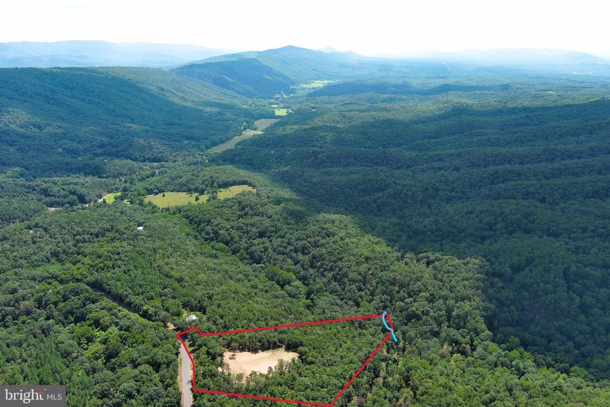 SUNSET HILL....6.56 WOODED ACRES WITH MASSIVE CLEARED BUILD/CAMP SITE WITH NEARLY 180 DEGREE VIEWS, FACES DUE WEST....WATCH THE SUN GO DOWN OVER THE FARTHEST MOUNTAIN RANGE YOU CAN SEE. PROPERTY SLOPES OFF THE HILL INTO A HIDDEN HOLLOW WITH "DUMPLING RUN" FLOWING ACROSS THE END OF THE LAND. SAVE BIG $$$$$ ON INFRASTRUCTURE COSTS....THE FORMER OWNER INVESTED 25K IN THE SITE CLEARING & DRIVEWAY, ELECTRIC ONLY 150 FT FROM BUILD SITE, APPROVED PERK.....PULL IN YOUR CAMPER ON DAY ONE BUT THIS LOT IS MEANT FOR A NICE HOME OR CABIN. LOCATED IN THE WELL MAINTAINED QUIET GATED COMMUNITY OF HAMILTON ESTATES....GET THAT WAY OUT THERE FEELING WITHOUT ACTUALLY BEING WAY OUT THERE.....ONLY 1/2 MILE OFF THE PAVED ROAD AND LESS THAN 10 MINUTES FROM ROMNEY, PUBLIC ACCESS ON THE SOUTH BRANCH OF THE POTOMAC RIVER AND FORT MILL RIDGE(500 acres of public hunting) NICE.......NICE LOT, NICE LOCATION, NICE PRICE! YOU DON'T HAVE TO TRY AND SEE THE FOREST THROUGH THE TREES ON THIS ONE....THE VISION IS IN PLAIN SIGHT!