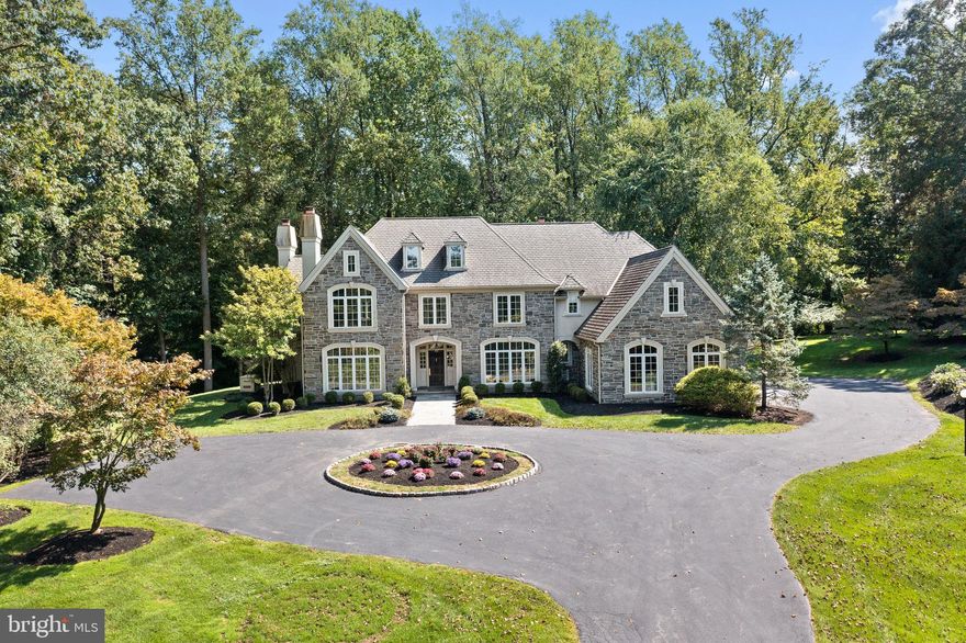 Welcome to 113 Knightsbridge Road, Wynnewood: a harmonious blend of classic charm and modern amenities. Nestled within the elite 14-home sanctuary of Knightsbridge, this Lee Haller built stone colonial stands out with outstanding features tailored for today's discerning homeowner. Upon entry, be captivated by a grand entrance foyer and center hall, leading to French doors that reveal an enchanting rear patio, merging indoor and outdoor experiences. To your right, the majestic formal dining room connects seamlessly to the gourmet kitchen via a butler's pantry. Dive into a culinary journey with premium appliances: a SubZero refrigerator, Thermador cooktop and ovens, and a Miele dishwasher. Anchoring the kitchen is a granite island, complemented by abundant cabinetry and a nearby powder room. Relish the sun-kissed mornings in the adjoining breakfast room, surrounded by expansive windows that frame the mesmerizing landscape. The adjacent family room radiates warmth from its gas fireplace. To the left, discover a large living room, complete with a fireplace, flowing effortlessly into a refined home office graced with floor-to-ceiling woodwork and gas fireplace. Another powder room offers added convenience. Ascending the main staircase unveils a landing with a charming window seat. Close by, the laundry room stands ready.
The primary bedroom suite showcases spacious walk-in closets and a bathroom with tub. Its expansive neighboring bedroom with en-suite bathroom offers potential for enlarging the primary bedroom or creating an additional bedroom. This floor also houses a third bedroom with a private bath and a versatile fourth bedroom/den with its own powder room, wet bar and bonus room. A rear staircase ensures fluid movement between levels. A dedicated staircase guides you to the third level, introducing a spacious bedroom suite with private bathroom. Notably, the home incorporates an elevator linking the main floors and the vast basement, equipped with a powder room and awaiting your bespoke touch. A generous three-car garage adds to the home's grandeur along with a generator.  For those seeking additional space an adjacent 1.04 acre Iot with separate dead is available for purchase. 113 Knightsbridge Road isn’t merely a residence; it’s a symbol of sophisticated living. Perfectly positioned on a picturesque lane, it embodies an enduring elegance paired with today's conveniences.