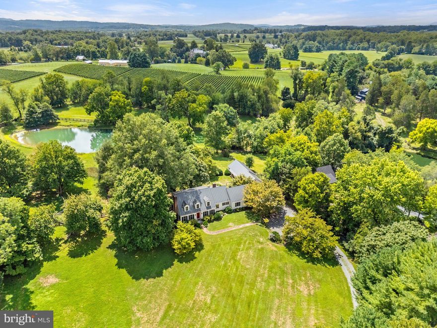 Price reduced! First time offering of a charming property located within the historic village of Middleburg – 503 W Washington Street. Set on nearly 2 acres, this Cape Cod style home offers 4 bedrooms and 3.5 baths providing a spacious and serene setting. Elevated on a knoll and set back from the road it opens to a private, fully fenced yard with mature landscaping, gardens, and a pond view creating a peaceful in-town oasis. The interior features a traditional floor plan starting with a welcoming front hall that leads to both the living room, complete with a fireplace, and the dining room. Towards the back there’s a home office (or main level bedroom), a full bath and a cozy wood paneled family room with a large brick hearth and wood-burning fireplace. The gourmet kitchen, updated with stainless steel appliances and granite countertops flows seamlessly into the family room making it perfect for entertaining. Upstairs the primary bedroom includes multiple closets and an ensuite bath while two additional guest bedrooms share a second full bath. There’s ample storage including a walk-in closet, an unfinished attic and space above the attached garage. The lower level offers over 1,100 square feet of room for future expansion. Entertain friends and family on the screened-in back porch and the picturesque flagstone terrace. The property also features a detached outbuilding with a one-car garage, a two-bay equipment shed, and an extra storage section which used to be stalls of a barn that served the original house on the neighboring property. Located on the west side of town, the home is within walking distance of shops, restaurants, and so much more. Be sure to watch the video. Only 35 minutes from Dulles International Airport and 1-hour from Washington, D.C. This rare gem offers the perfect combination of space, privacy, and convenience in the heart of Middleburg. Don't miss!