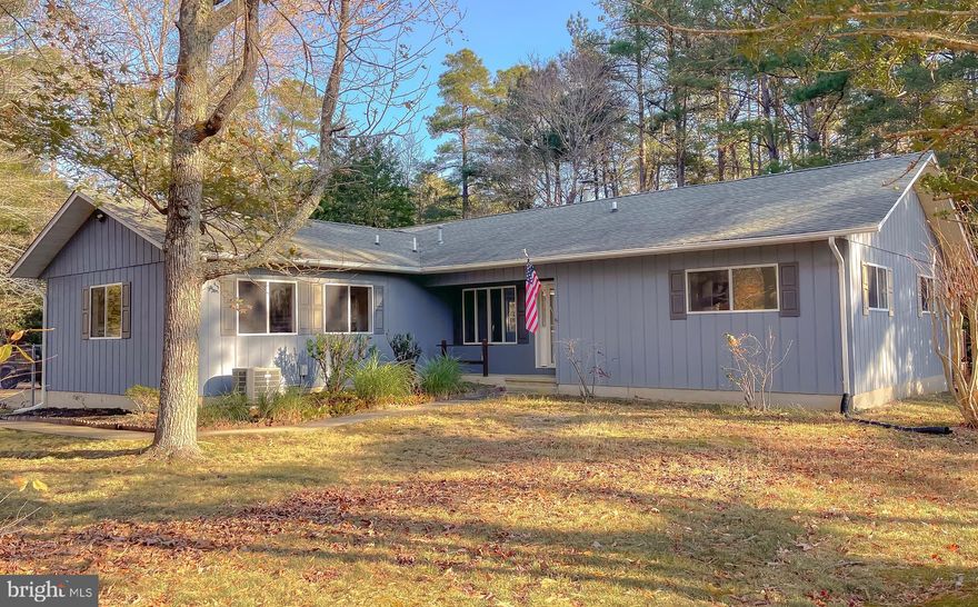 PRICE IMPROVEMENT! Nestled in nature, this delightful 2-bd/2-ba rambler is set on a 1-acre corner, wooded lot. Spacious open-concept interior between living, dining and kitchen. Good looking, easy-care laminate flooring in living room and  brand new laminate flooring in bedrooms.  Kitchen offers a brand new dishwasher, gas cooking, island w/breakfast bar and big pantry. Warm up the house with the centralized wood stove. Ceiling fans throughout. Primary bedroom w/ attached bath , closet/extra hanging space and sliders out to back deck. Second bedroom has private access to hall bath - perfect for guests! Enjoy the great outdoors on the big back deck perfect for entertaining. Kids and dogs can run in the fully-fenced yard. A two-car garage and oversize shed provide plenty of storage. 30-year shingles on a 10-year old roof and newer deck is in great condition. Privacy abounds, but this home is minutes from shopping and main commuter routes. Come home to relaxation in this quiet, natural setting. Don't miss your opportunity to see this affordable beauty, schedule your showing today!