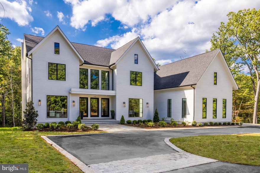 Inspiration lives well at 736 Gold Mine Rd, a new construction offering on five private acres with Potomac Riverfront access in Bulls Neck, McLean. This amazing  home has come to life from the combined vision of top industry-leading specialists, a premier builder Brush Arbor Homes, award-winning architect WC Ralston, and interior design house Wellhouse & Co.

This transitional design offers unprecedented standards while offering the pinnacle of estate living on a private road. Truly seamless indoor-outdoor entertaining and more all come together with unmatched modern styling and the sense that anything is possible… and always right within reach. The house encompasses 6 bedrooms - each with private ensuite bathrooms - in a floorplan which covers 8000 SF+/- of interior space, with ample room for a future pool and also a shaft for future elevator. 

Designed to offer its future residents a wonderful lifestyle like no other, the home takes the indoor/outdoor living to the next level due to the floor to ceiling windows and multiple sets of sliding doors which allow an abundance of natural light to fill the home from nearly every room. Numerous outdoor porches and patios are staged over a series of levels and locations to create countless opportunities to enjoy the outdoors. Anchored by an impressive entry with a massive white oak staircase and featuring large custom glass and metal doors with a dramatic foyer allowing light from above to flow down, the main level's plan and design maximizes the use of traditional molding and transitional yet timeless finishes. 

The main living space features a library or living room with a full bath, formal dining room with butler’s pantry, a stunning glass wine wall partitioning the formal and casual sections of the home, a gracious great room with a beautiful gas fireplace with floor to ceiling slab quartzite-inspired surround, mudroom, walk-in pantry, and two powder rooms. The art of cuisine and exquisite taste finds its home in a gallery-quality kitchen with flawless presentation and premium appliances, including a built-in espresso machine and full-wall paneled refrigerator and freezer.

An inviting openness between the kitchen, dining, and living areas allows life to flow easily from one moment to the next. More than a bedroom, the Primary Suite serves as a retreat within the retreat – where vistas and serenity can be enjoyed without compromise. The primary retreat features sliding glass doors opening to a large private terrace overlooking the rear yard. Thoughtfully designed to ensure privacy and serenity, the oversized closet is dually connected to the luxuriant bath and the bedroom. The luxuriant wet room spa bath is complete with a free-standing soaking tub, large shower, a water closet, and dual vanities.

A bonus guest or au-pair suite above the garage brings an additional sense of privacy to a separately accessed corner of the home, while still granting the inspiration of the world outside just steps away. In quiet repose or engaged in social enjoyment, 736 Gold Mine provides the ideal setting for whatever captures the imagination. Sited beautifully on a private road with private trail access to the Potomac River, this home offers close proximity to Georgetown Pike, and is also ideally situated just minutes to the George Washington Parkway, 395, Tyson’s Corner, and the Capitol Beltway. *note - wooden open shelving is still to be installed in Butler Pantry