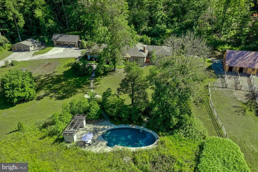 The Country Home that has it all - beautiful entertaining & living space, pool, horse barn, in-law apartment, plus a separate guest cottage.  Private 7.5 acre Chester Springs property a short walk from the Birchrunville Cafe and Butterscotch Pastry Shop. This updated raised ranch home is situated in a quiet location surrounded by rolling hills, yet is just minutes from major transportation routes, including the Exton train station and Turnpike access -- it could not have been positioned better.  Pull in past the adorable classic guesthouse and up the driveway to the garages with indoor parking for 5 vehicles, cabinets, and workbenches.  Frank Lloyd Wright style formal Living Room and Dining Room with a full wall of windows allowing you to take in the views. The distinguished space features built in cabinets, beamed ceiling, brick hearth wood burning fireplace, pegged Pennsylvania pine floors, and powder room nearby.  Head to the heart of the home, the breathtaking custom built eat-in Kitchen all new in 2011, sure to please the aspiring chef with ample space for lingering guests.  Sub-Zero-Wolf-Bosch appliances, 6-burner Viking gas stove with grill, 2 dishwashers, double-oven, and warming drawer.  Stunning Italian soapstone counters, custom tile backsplash, large center working island with storage, seating, prep sink, and pendant lighting, window seats in the breakfast nook, all this plus a Butler's Pantry wet bar & wine chiller. A striking wood cathedral ceiling, skylights to brighten the room, ceiling fan to keep the cook cool, tall cabinetry with lighted transom glass display toppers.  Gaze through to the Family Room with custom built-in bookcases, crown molding, beamed ceilings, recessed lighting, bay window, wood burning fireplace with detailed woodwork mantel and pegged pine floors.  The owner's wing of the home, all new in 2011, boasts a massive Bedroom with tray ceiling, recessed and chandelier lighting, walk-in organized closet, full luxury Bathroom with steam shower, soaking tub, dual sinks and vaulted ceiling, as well as a separate Office with pocket doors for privacy.   Three additional good-sized Bedrooms on the main floor with large closets, one with En Suite Bath as well as a Hall Bath are on the opposite end of the home.  Descend to the lower level and set your eyes on the open and bright finished lower level hosting an in-law/au pair suite with full Kitchen, Dining area, Family room, Walk-in closet, enormous full Bath with roll-in shower and Bedroom with access to the lower Patio.  In addition to the recreation room, there is an unfinished portion of the lower level with Laundry, Utilities and Storage. Bonus features include energy efficient zoned radiant heated flooring throughout the main house, multi-zone Fujitsu split air conditioning, reverse osmosis water filtration, and Generac backup electrical power.  The estate's outbuildings include a new Barn built in 2018 with wash stall, tack room, hay loft, hot and cold water and electric. The in-ground saltwater heated swimming pool is surrounded by a stunning garden of flowers and shrubs.  The historic Guesthouse, renovated in 2011, is located right at Flowing Springs Road and sleeps 4 with a downstairs Bedroom, Kitchen, Living Room and a loft with 2 beds upstairs and was a successful Airbnb in recent years.  The immediate area is popular with cyclists and nearby trails (including Bryn Coed) entice hikers and horseback riders.  This combined with easy access to Mainline shopping and dining provides a plethora of potential activities.  Live, play, and work from this breathtaking property.