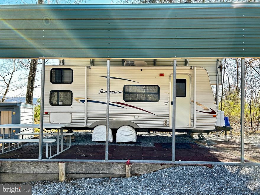 Channel your inner mountaineer as you feast your eyes on this awesome 10+ acre lot with gorgeous views! Located on the fringe of the Sleepy Creek Wildlife Management Area, which is a "haven for hunters, fishermen, plant and outdoor enthusiasts!  Did you know that Sleepy Creek is almost 23,000 acres and has a 203 acre lake?  If that's not enough to excite you, this lot also comes with a 2010 Springdale camping trailer, with electric already hooked up.  There's also a 275 gallon water tank on the property (you have to refill), all the "luxuries" of home inside of the camping trailer as well (stove, refrigerator, microwave, air conditioning and heat). The camper is contained under a tall carport structure for protection and so that you can enjoy picnics on "patio".  Although the land has a manageable slope, there's alot to behold in this little slice of Heaven including walking trail, Big Run Creek with cute bridge to access it, and several spots that are flat to eventually build your dream home.  Escape from the city life and turn yourself on to the adventure that awaits you at this affordable property.  Plenty of area to hunt, with small shelters to keep out the cold.  Access road is easy to travel on and well maintained.  Make an appointment to experience this breath of fresh air, a, place to make memories and eventually build your forever home away from the concrete jungle.