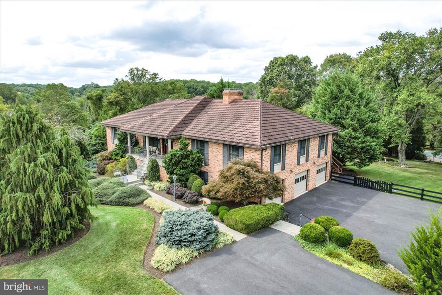 This elegant Clifton property is a rare find! Situated on 5.34 private acres of rolling hills arrayed with a lovely home, an in-ground pool, shed, horse pastures and a historic horse barn built with Pre-Civil War lumber from an old Red Cross Hospital. This wonderful property provides the perfect ambiance of country living with the nearby amenities of city life. The spaciously and well designed home — nearly 5,400 sqft — features  an enormous 3-door garage and two levels of living with all the conveniences of a single-level home, including an elevator. The lower level, with its own entrance and kitchenette, has the perfect makings for a “mother-in-law suite.” The main level hosts the kitchen as the center of the home with custom finishes that are open to the warmth of a gas log fireplace and light-filled breakfast area. The hardwoods throughout the main level are like new, and the upgraded Marvin windows and doors allow for great viewing of the serene outdoors. Updates have been made to every space in the home, including custom built-ins, new lighting/ceiling fans, newer toilets, newer shower, new faucets, newer 80 gal water heater, Lifetime Metal shingle roofing, newer oil tank, refreshed pool and decking, whole house generator from Generac, and more. The blue stone porch, extra large covered flagstone patio running the length of the house, main-level walkout deck that runs 3/4 the length of the house, and in-ground pool will quickly become the family's favorite outdoor gathering places. Indoors you have 3 fireplaces each with a gas insert.
     This amazing estate offers acres to run, play soccer, garden, land a helicopter, groom horses, raise chickens and so much more. You will love living here! — centrally located, highly rated schools, and tons of outdoor activities — this property is a dream! It is a quick drive to major commuter routes (Rt 66, Rt 123, Fairfax County Parkway), Virginia Golf Center, Twin Lakes Golf Course, Hemlock overlook Park, Bull Run Park Marina (offering sports fields, hiking trails, fishing and kayaking), Clifton's own Paradise Springs winery, and many of Northern Virginia's historic towns.